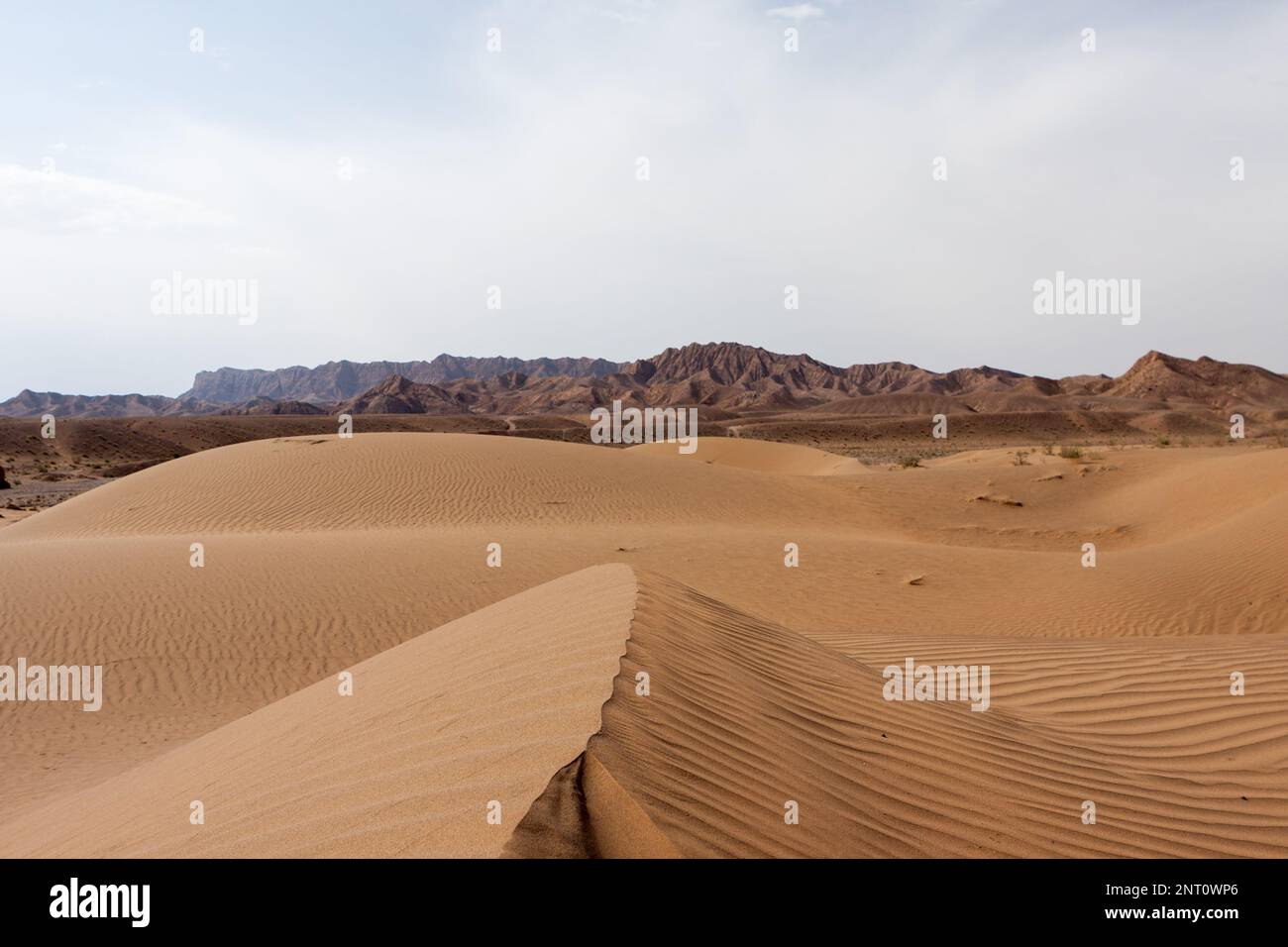 Dune di sabbia del deserto di Dasht-e Kavir con montagne all'orizzonte, Iran. Foto Stock