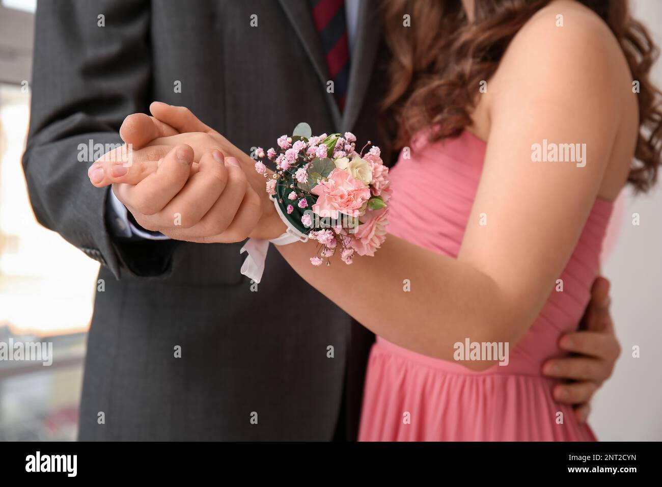 Giovane uomo e la sua data di Prom con corsage tenendo le mani, primo piano Foto Stock