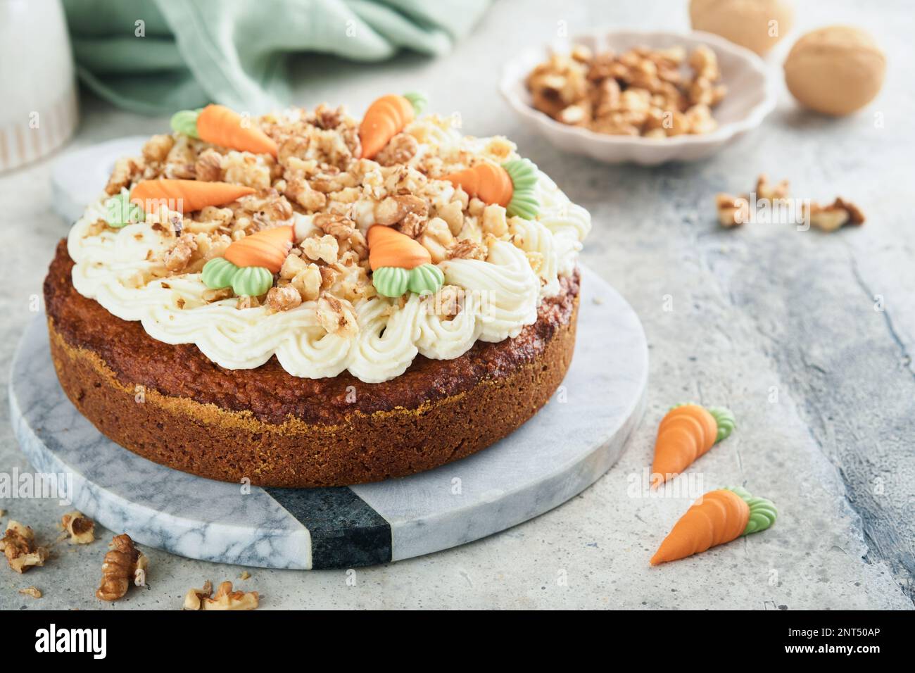 Torta di carota di Pasqua con gelato al formaggio cremoso. Deliziosa torta di carote con noci e crema di formaggio glassa sul tavolo grigio di fondo in cemento per festi Foto Stock