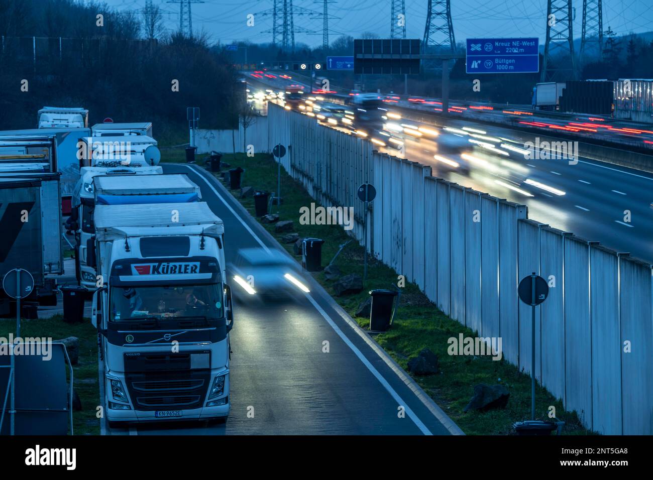 Autostrada A57 nei pressi di Kaarst, nel quartiere Reno di Neuss, vista in direzione dello svincolo di Büttgen, traffico serale intenso, parcheggio, pieno di camion Foto Stock