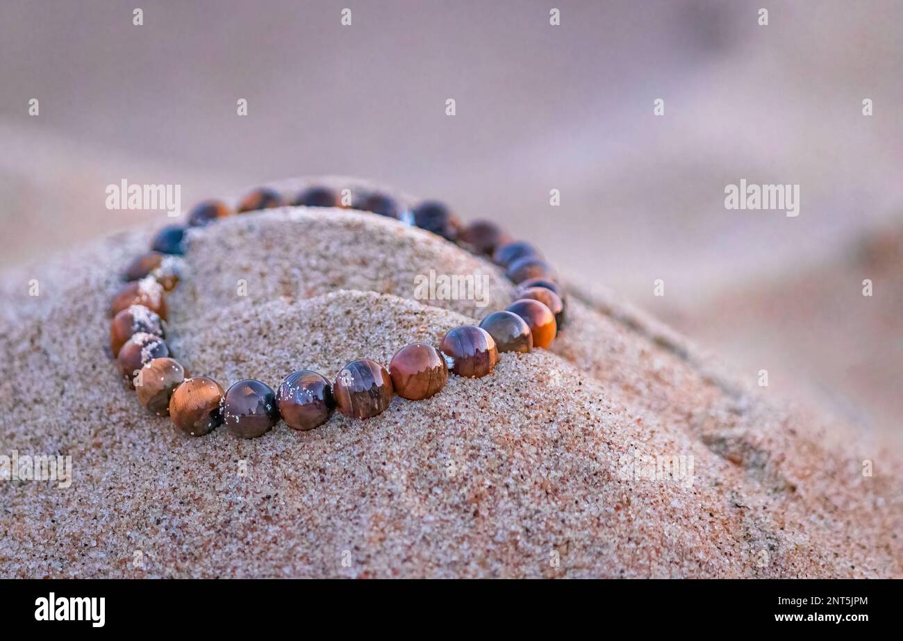 Cristallo tiger Eye sulla spiaggia di sabbia a Bournemouth, Inghilterra Foto Stock