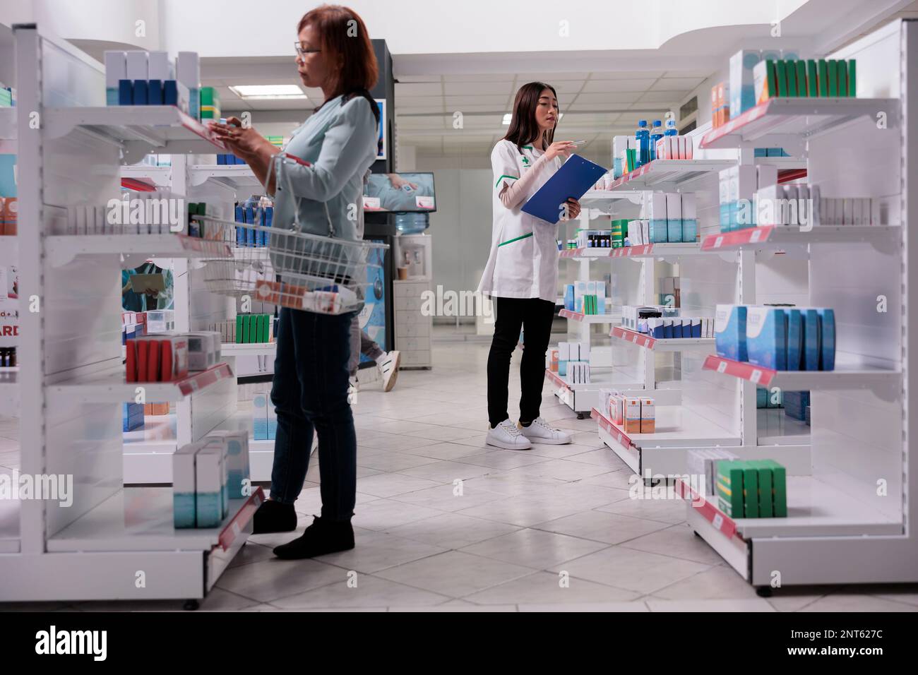 Farmacista che esamina i prodotti medici sugli scaffali, che controlla i farmaci della farmacia e le forniture sanitarie. Utilizzo di scatole di medicamenti per vendere prescrizione medica e trattamento. Foto Stock