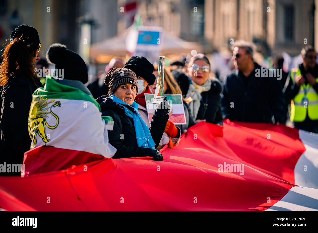 Donna che detiene una grande bandiera pro-monarchia in Trafalgar Square a Londra a sostegno del cambio di regime in Iran. Foto Stock