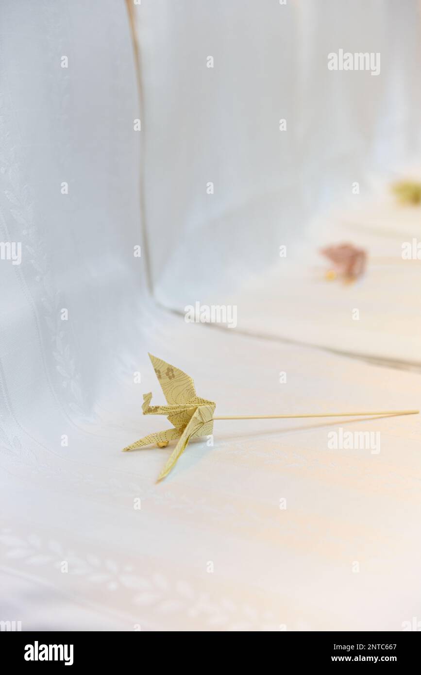 Carta giapponese gru origami su sfondo bianco. Dettagli matrimonio. Foto Stock