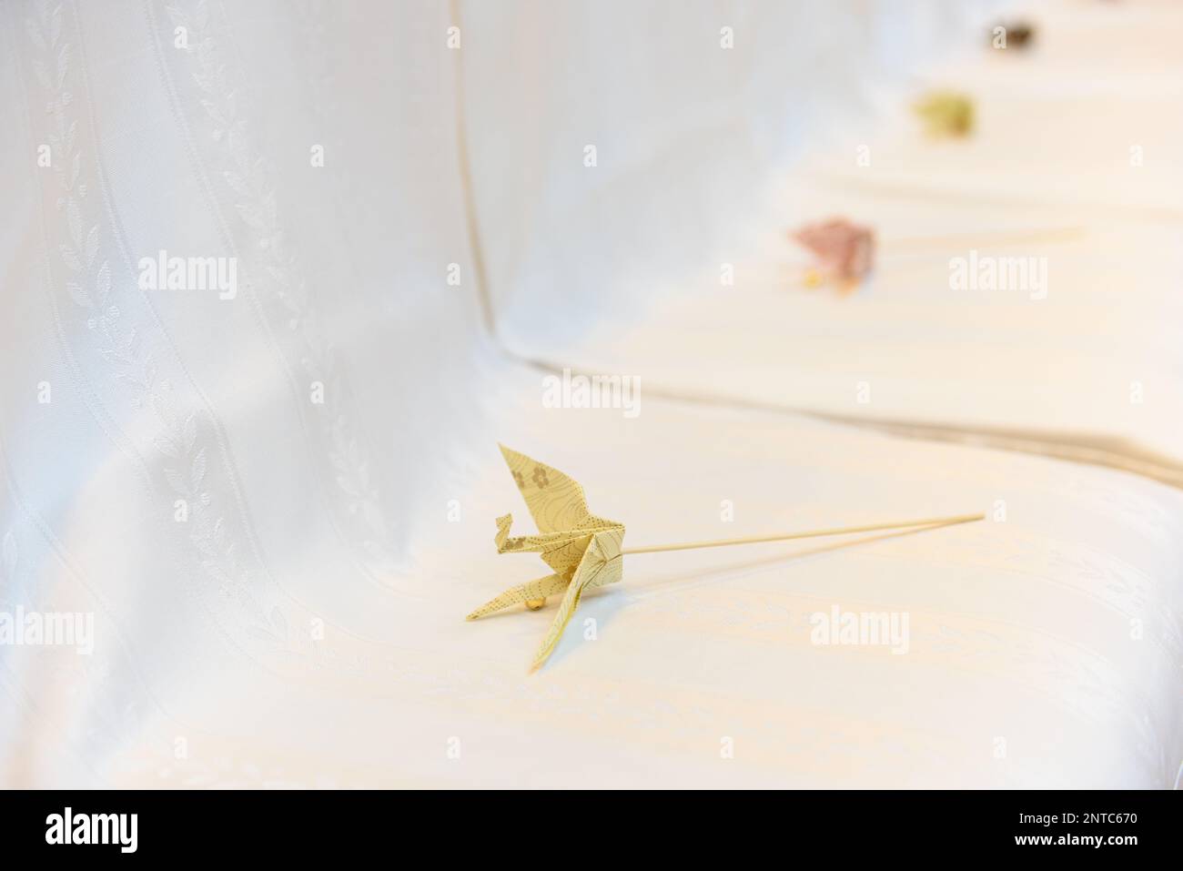 Carta giapponese gru origami su sfondo bianco. Dettagli matrimonio. Foto Stock