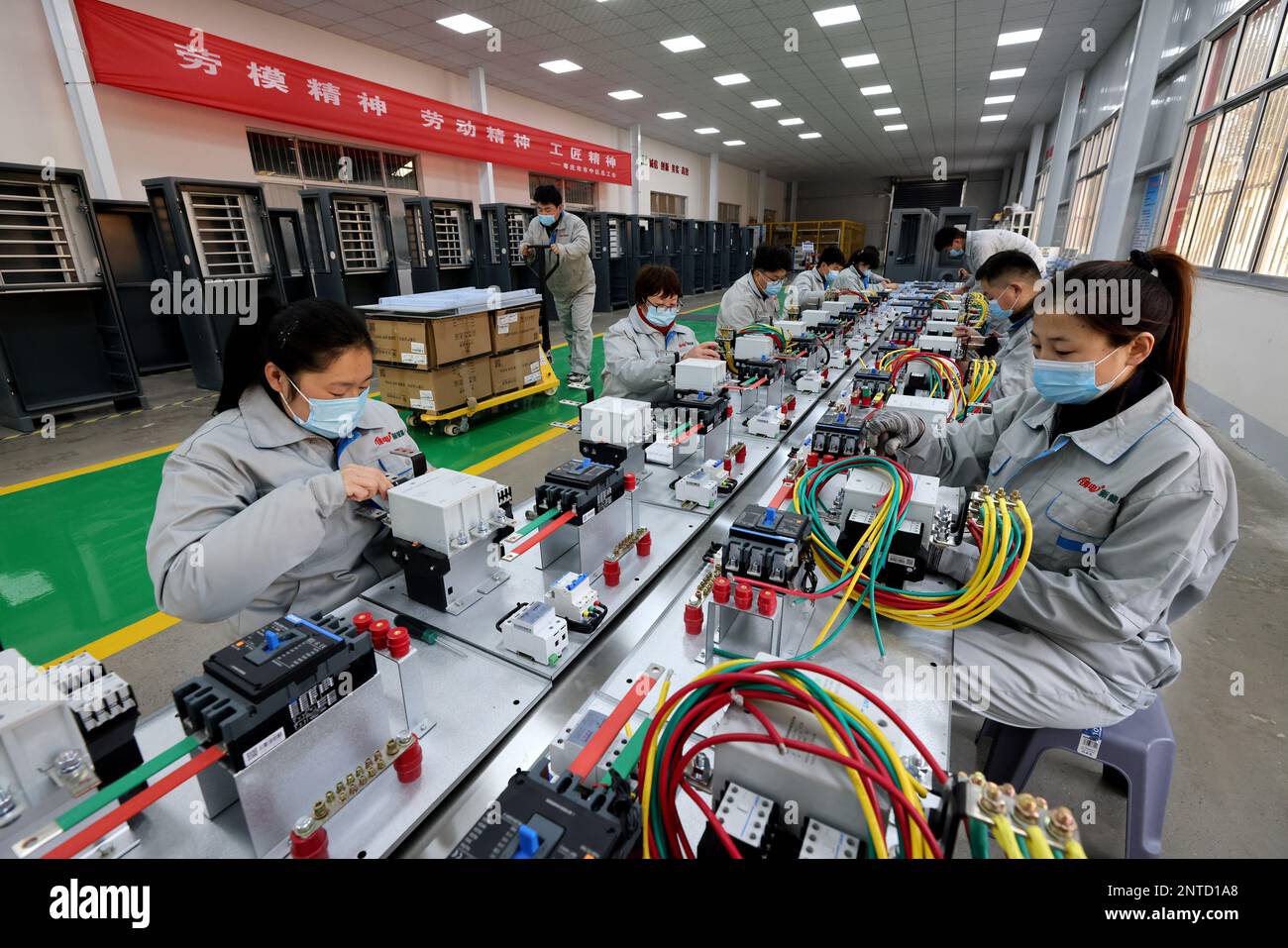 ZAOZHUANG, CINA - 27 FEBBRAIO 2023 - lavoratori qualificati fanno attrezzature di ricarica per veicoli di nuova energia in un'officina di Shandong Dingsheng Electric EQ Foto Stock