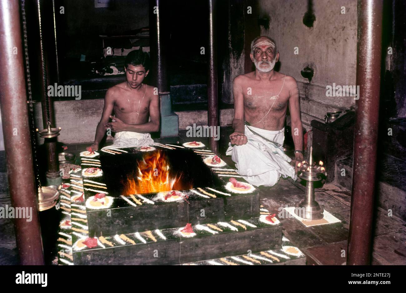 Nonno e nipote che esibiscono Pooja Agni Havana Homa Kunda Pooja indiano tradizionale Pooja, Kerala, India del Sud, India, Asia Foto Stock