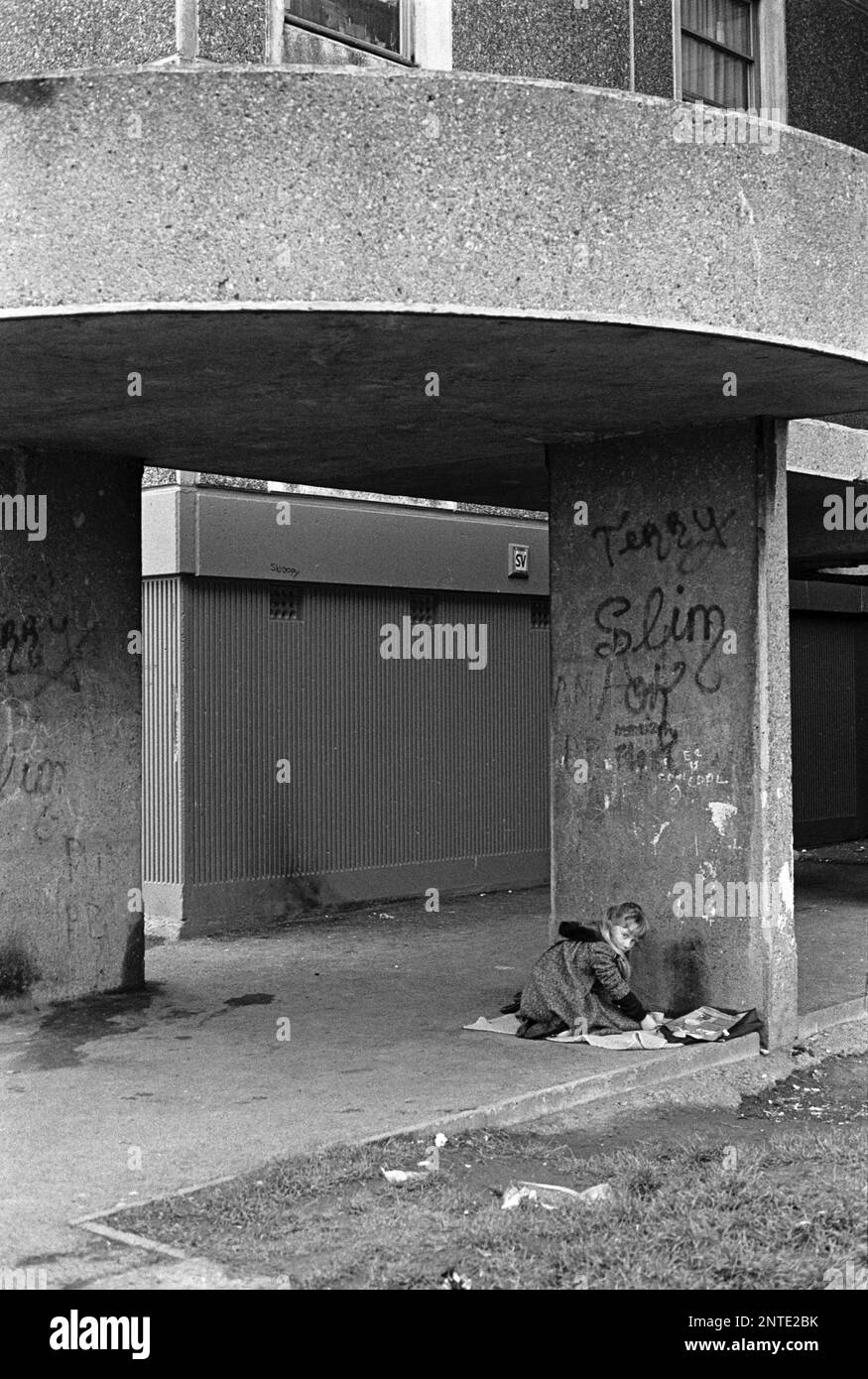 Ragazza che gioca nella zona di ingresso, alto edificio, Ballymun, Dublino, Irlanda, Gennaio 1986 Foto Stock
