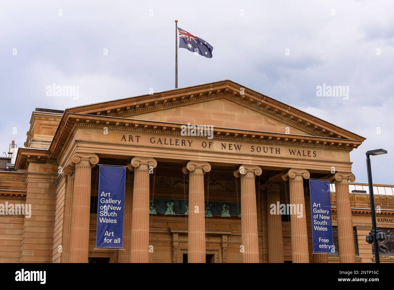 La facciata della Galleria d'Arte del nuovo Galles del Sud con colonne ioniche e una bandiera australiana in cima ad essa Foto Stock