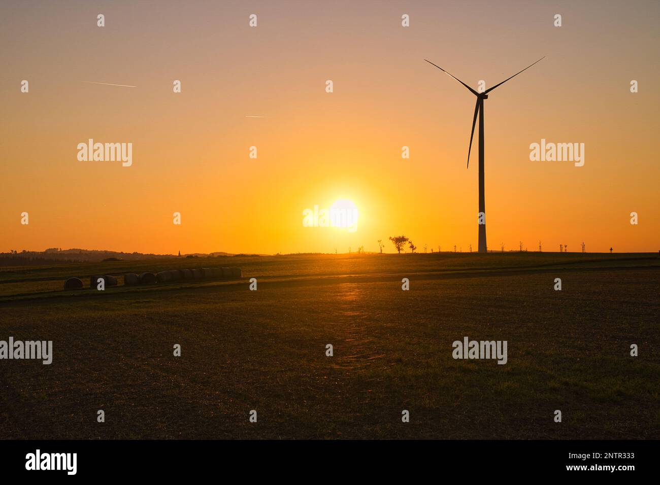 turbina eolica onshore su un prato al tramonto. Energia rinnovabile. Elettricità pulita. Foto del paesaggio industriale Foto Stock