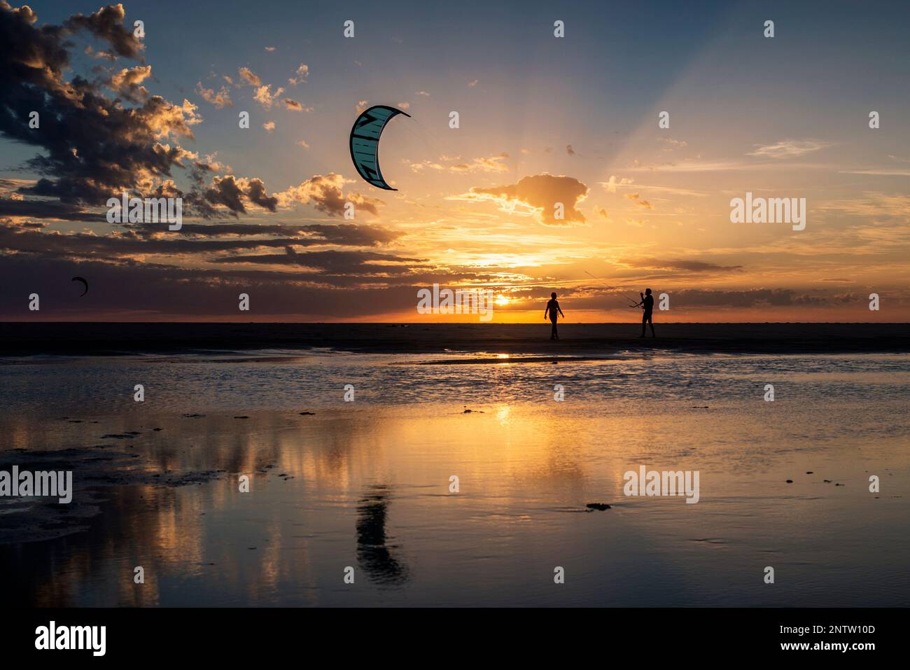 Gente kite surf al tramonto sulla spiaggia di Los Lances, Tarifa, provincia di Cadice, Andalusia, Spagna Foto Stock