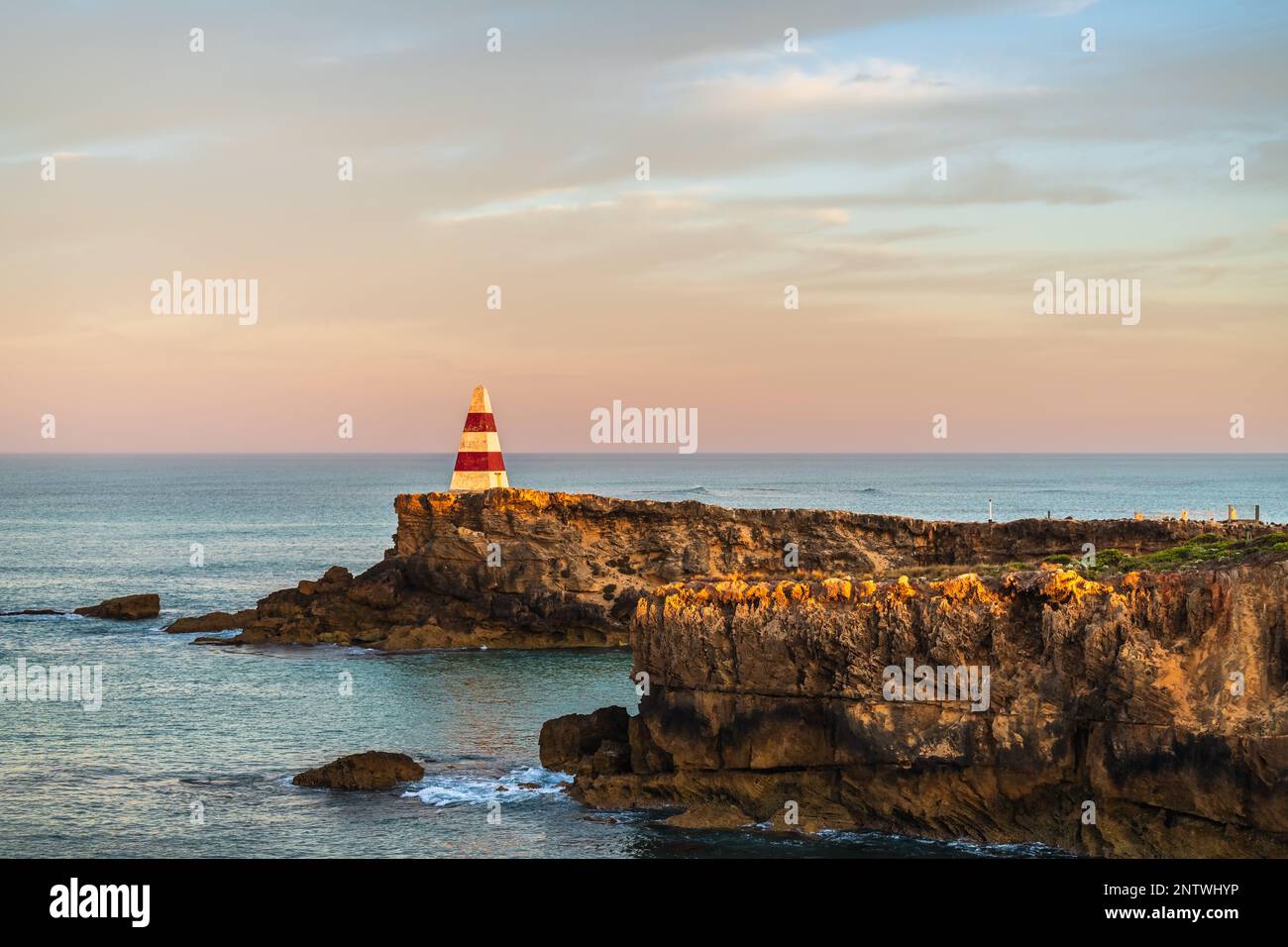 L'iconico Obelisco di Robe all'alba vista verso l'oceano. Un monumento senza tempo che rappresenta la prova del tempo a causa dell'erosione costiera Foto Stock