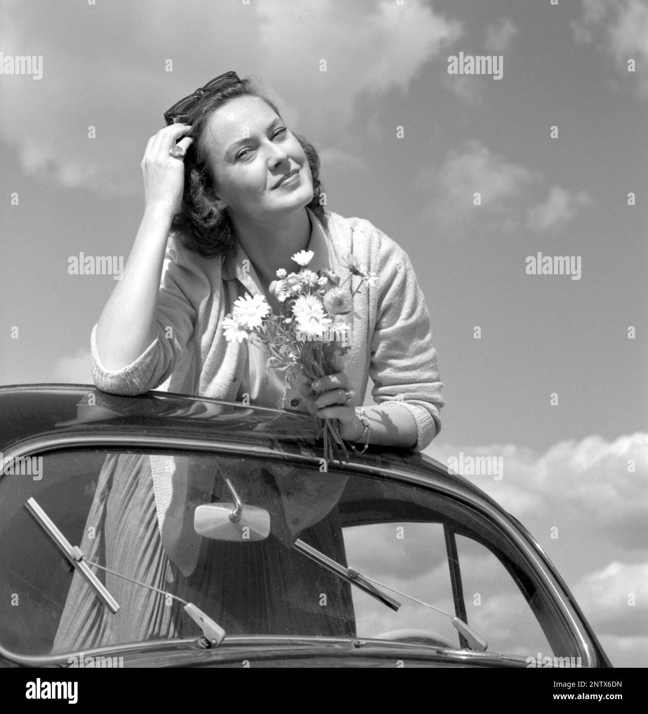 Negli anni '1960s. L'attrice Gaby Stenberg è felice di avere la parte superiore della sua auto Volkswagen Beetle. Svezia 1960 Conard Ref 4232 Foto Stock