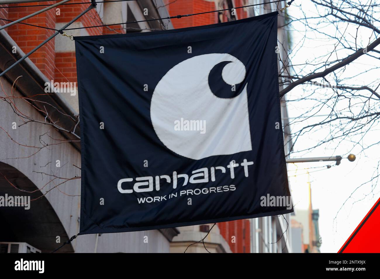 L'insegna con il logo Carhartt su una bandiera fuori da uno dei loro negozi di New York City Foto Stock