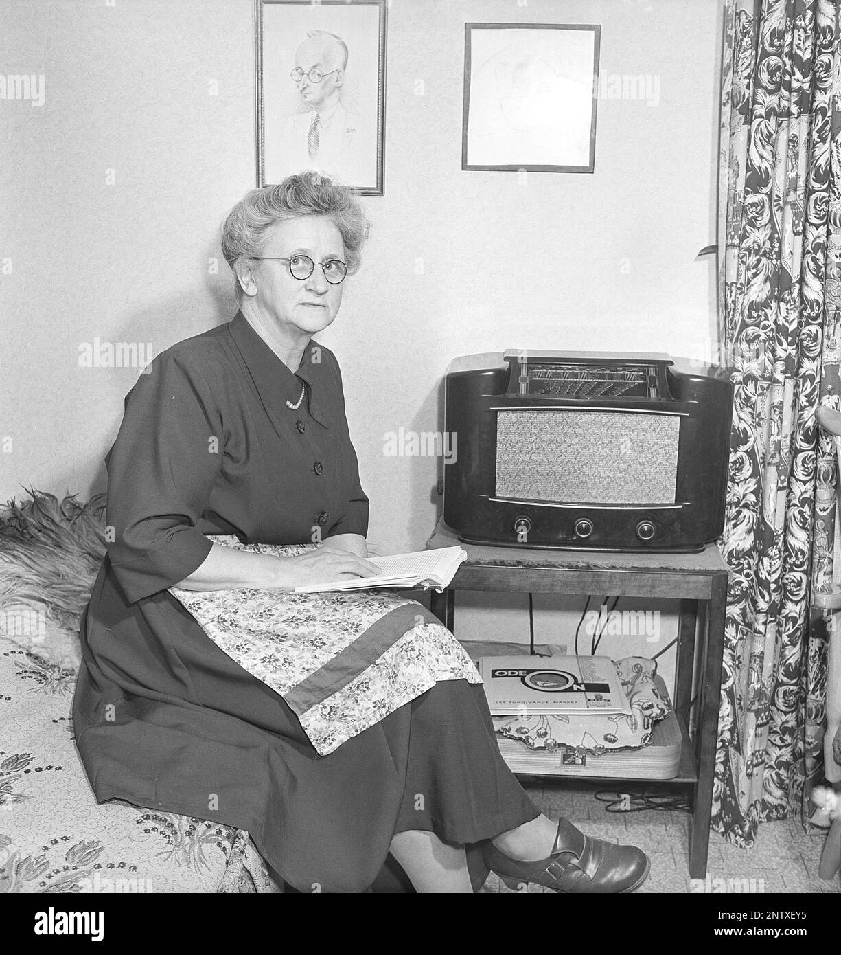 Ascoltatori radio in passato. Quattro giovani donne nello spogliatoio di un teatro di Stoccolma si siedono vestite con i loro abiti da palco e si riuniscono intorno ad un piccolo apparecchio radio, ascoltando con ansia. Sulla parte anteriore della radio è presente una scala e quando si ruota la manopola accanto ad essa in modo che il puntatore si trovi al centro del nome di una stazione, la stazione era lì. Oltre alle trasmissioni FM, hanno anche ascoltato le radio straniere a onde lunghe. Svezia nel 1949 Kristofferson Ref AT25-11 Foto Stock