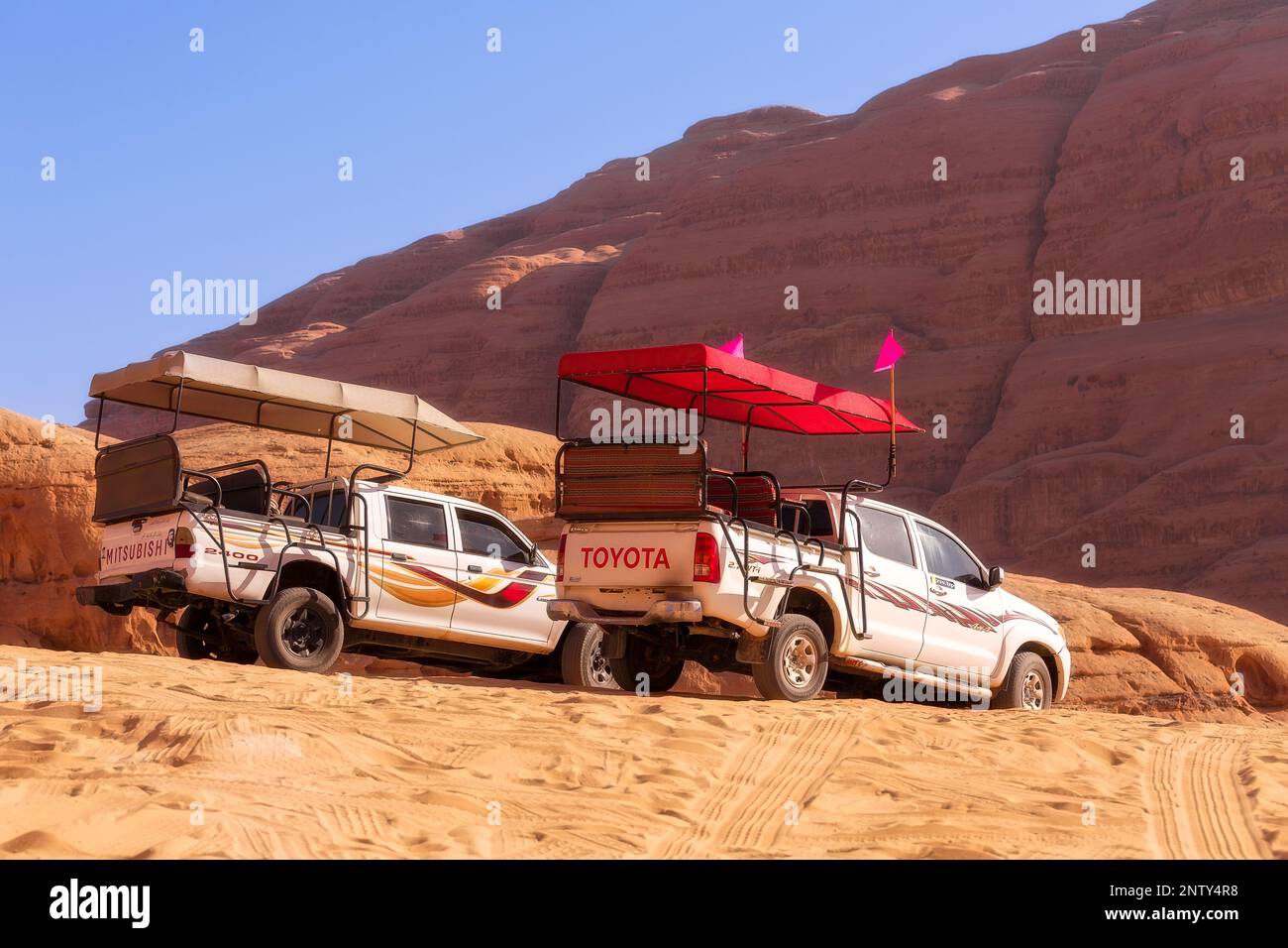 Giordania, Wadi Rum - 2 novembre 2022: Jeep beduina tour auto nel deserto con scogliera montagna rocciosa sullo sfondo Foto Stock