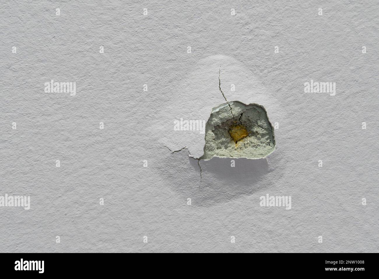 Vista ravvicinata della struttura della parete viola incrinata e dei fori. Foto Stock