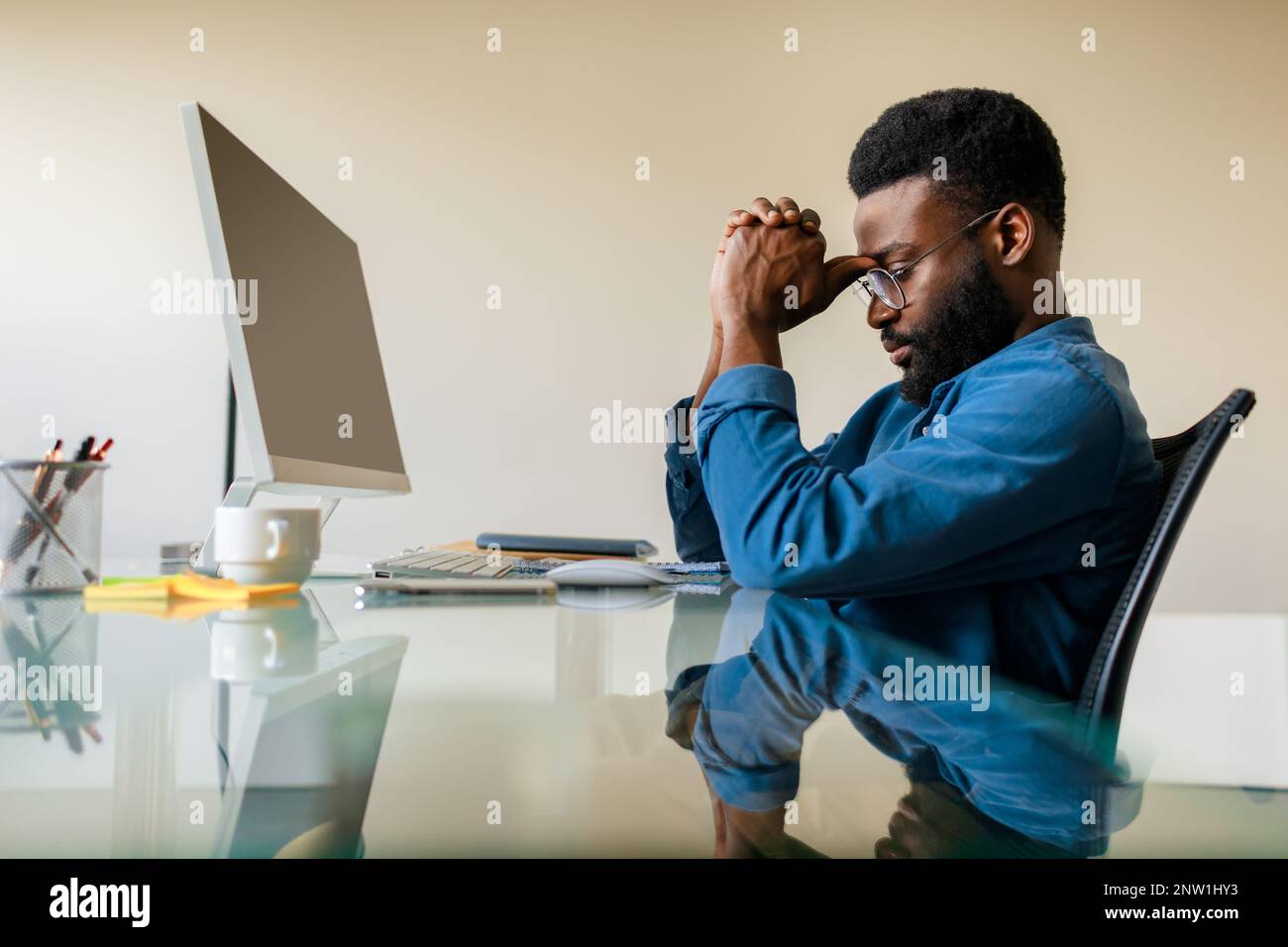 Arrabbiato uomo d'affari nero penoso seduto alla scrivania con computer, analista professionista maschio pensiero di soluzione del problema Foto Stock