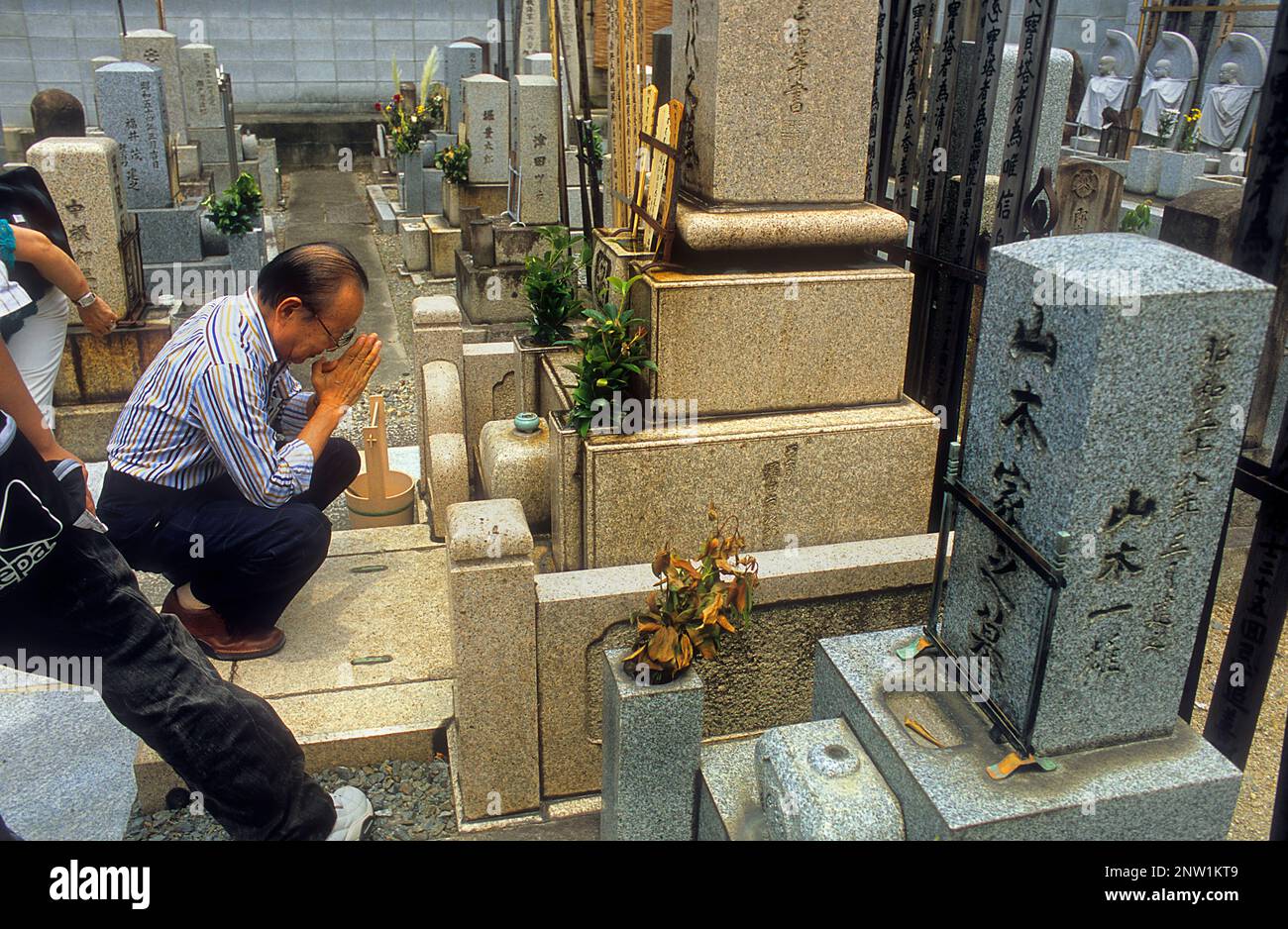 Pregando presso il cimitero vicino al Nishiki Tenman-gu cappella,Kyoto, Giappone Foto Stock