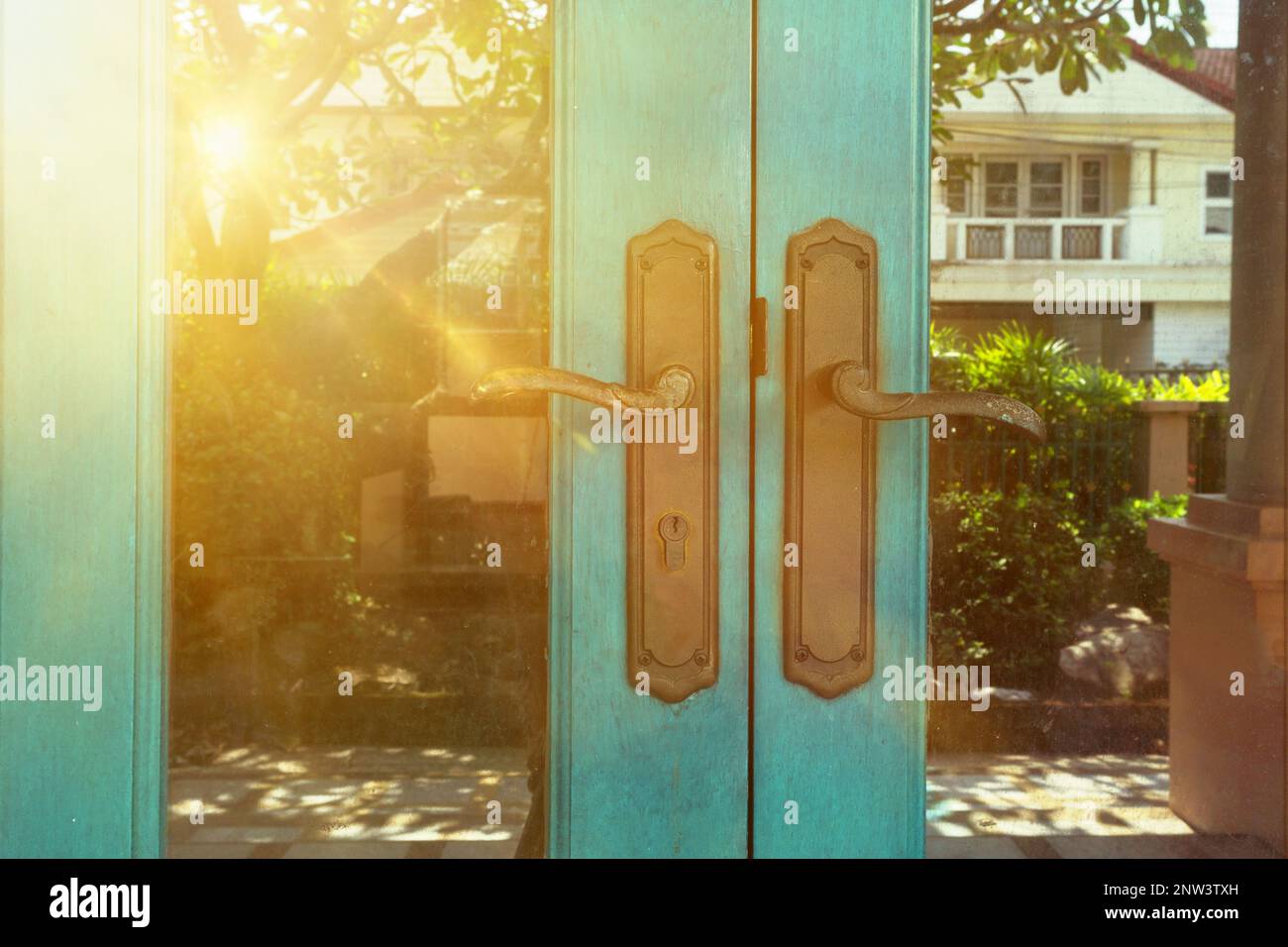 antico antico oro ornato maniglia porta serratura, pomolo porta, tramonto giardino piccolo villaggio Foto Stock