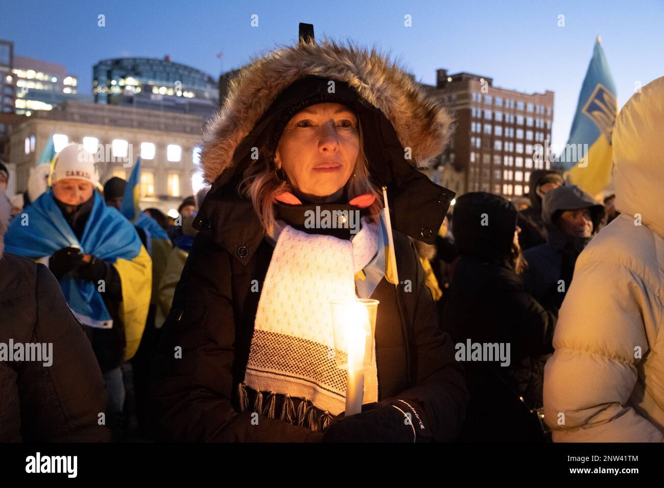 Una giovane donna durante una protesta che mostra solidarietà per gli ucraini con le candele accese in mano Foto Stock