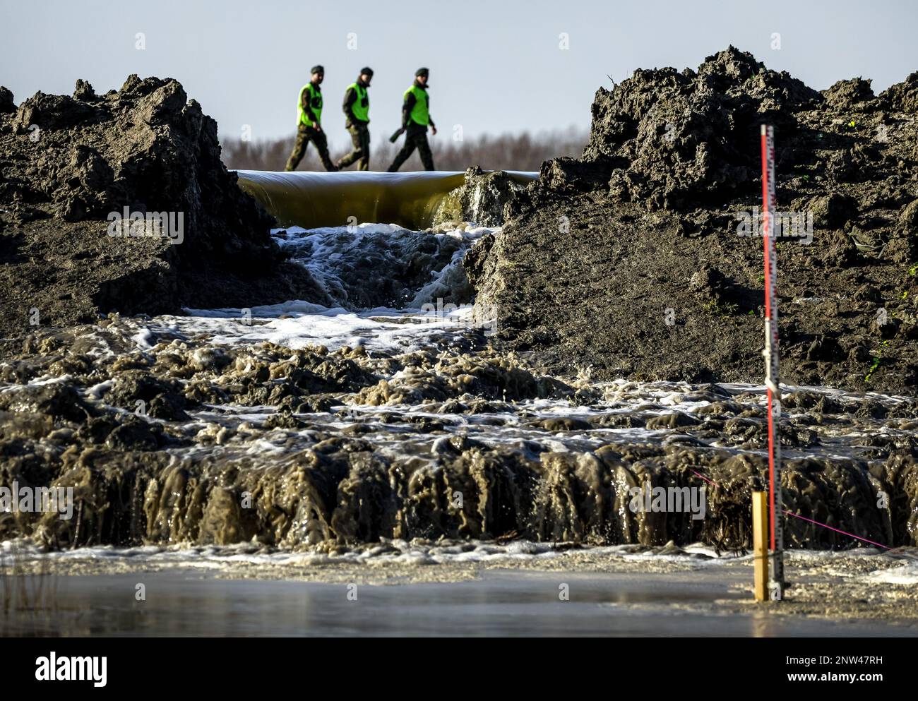 MARNEWAARD - 28/02/2023, gli esperti di difesa e acqua utilizzano esplosivi per soffiare un buco in una diga di prova sul campo di addestramento del Ministero della Difesa a Groningen. Lo scopo della prova è di scoprire se soffiare su una sezione di diga può aiutare contro inondazione in tempi di acqua estremamente alta. ANP REMKO DE WAAL olanda fuori - belgio fuori Foto Stock