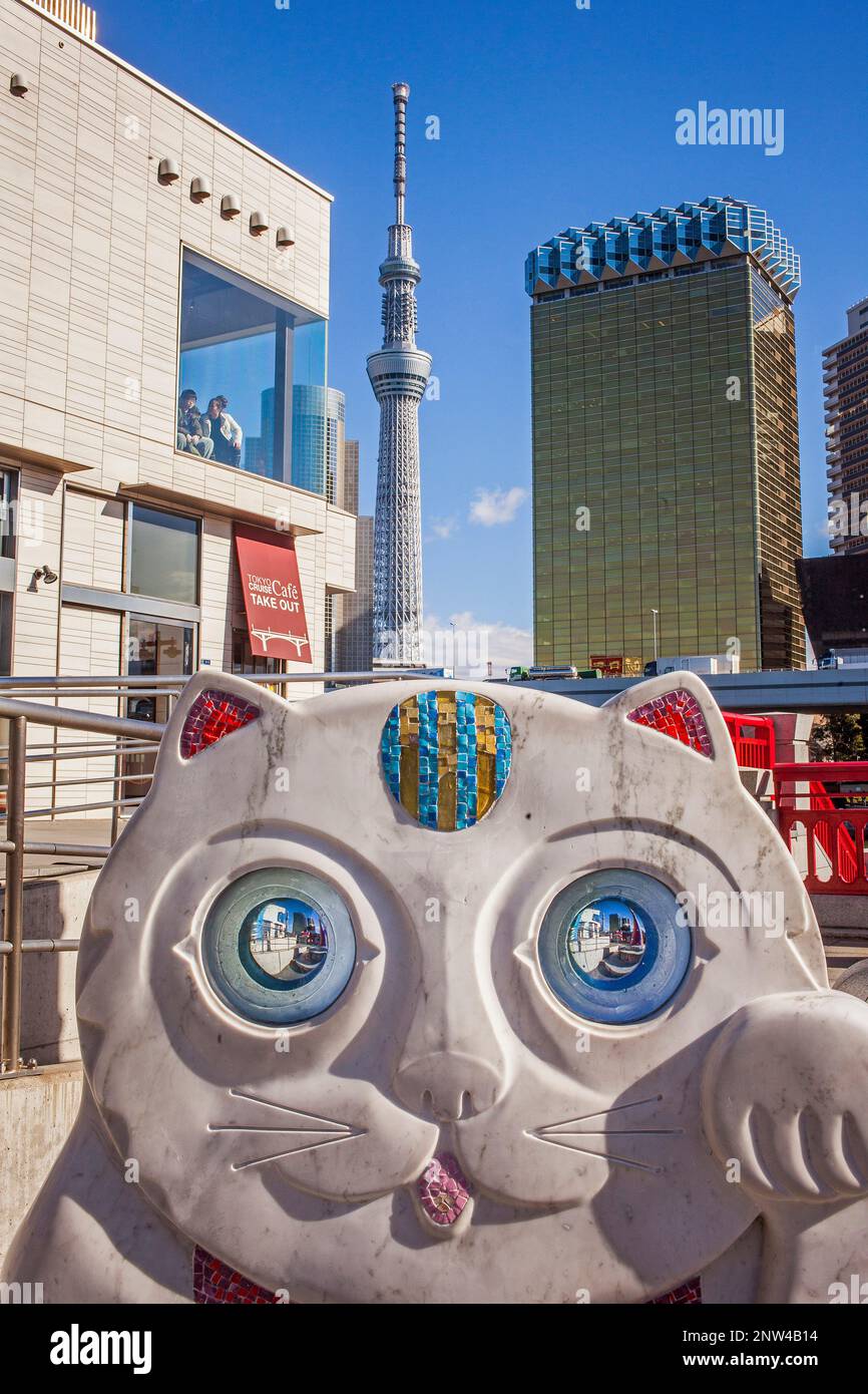 Scultura di lucky Cat (Maneki Neko), a ponte Azuma, in background struttura Sky Tower, il quartiere di Asakusa, Tokyo, Giappone Foto Stock