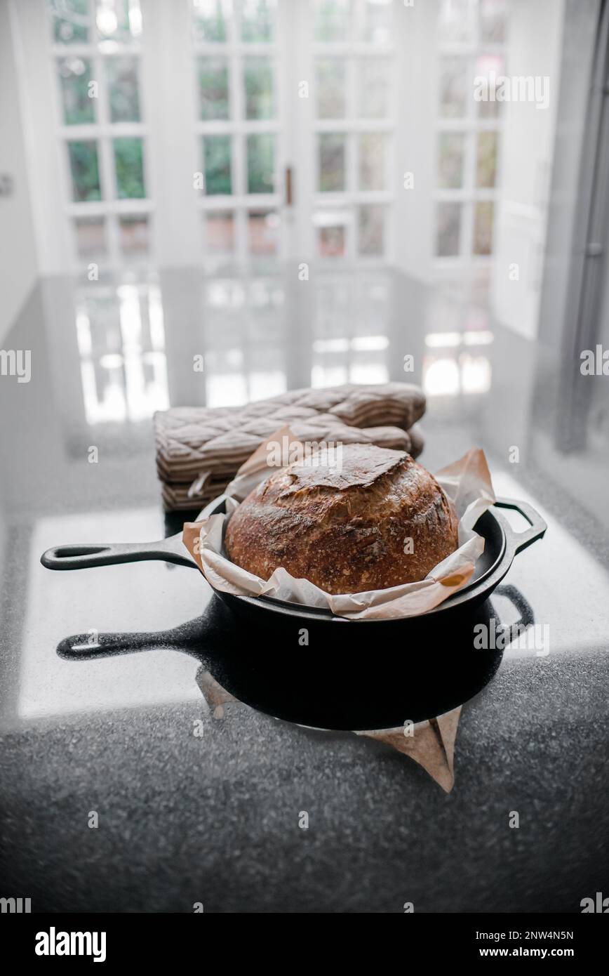 Pane di pasta madre appena sfornato in una pentola in ghisa Foto