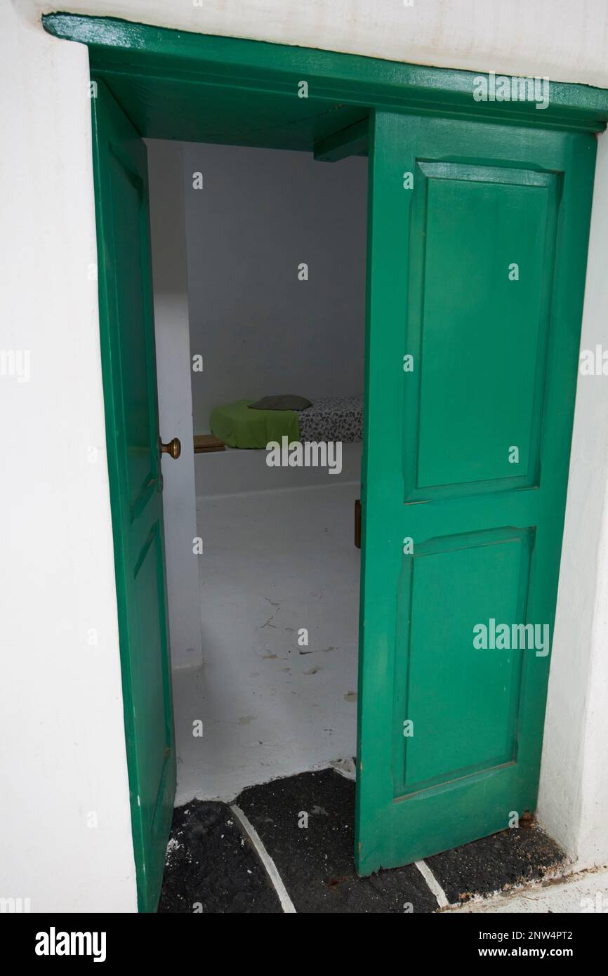 Porta dipinta di verde si apre in camera dal cortile del tradizionale finca casa colonica imbiancata dimora storica a Lanzarote, Isole Canarie, S Foto Stock