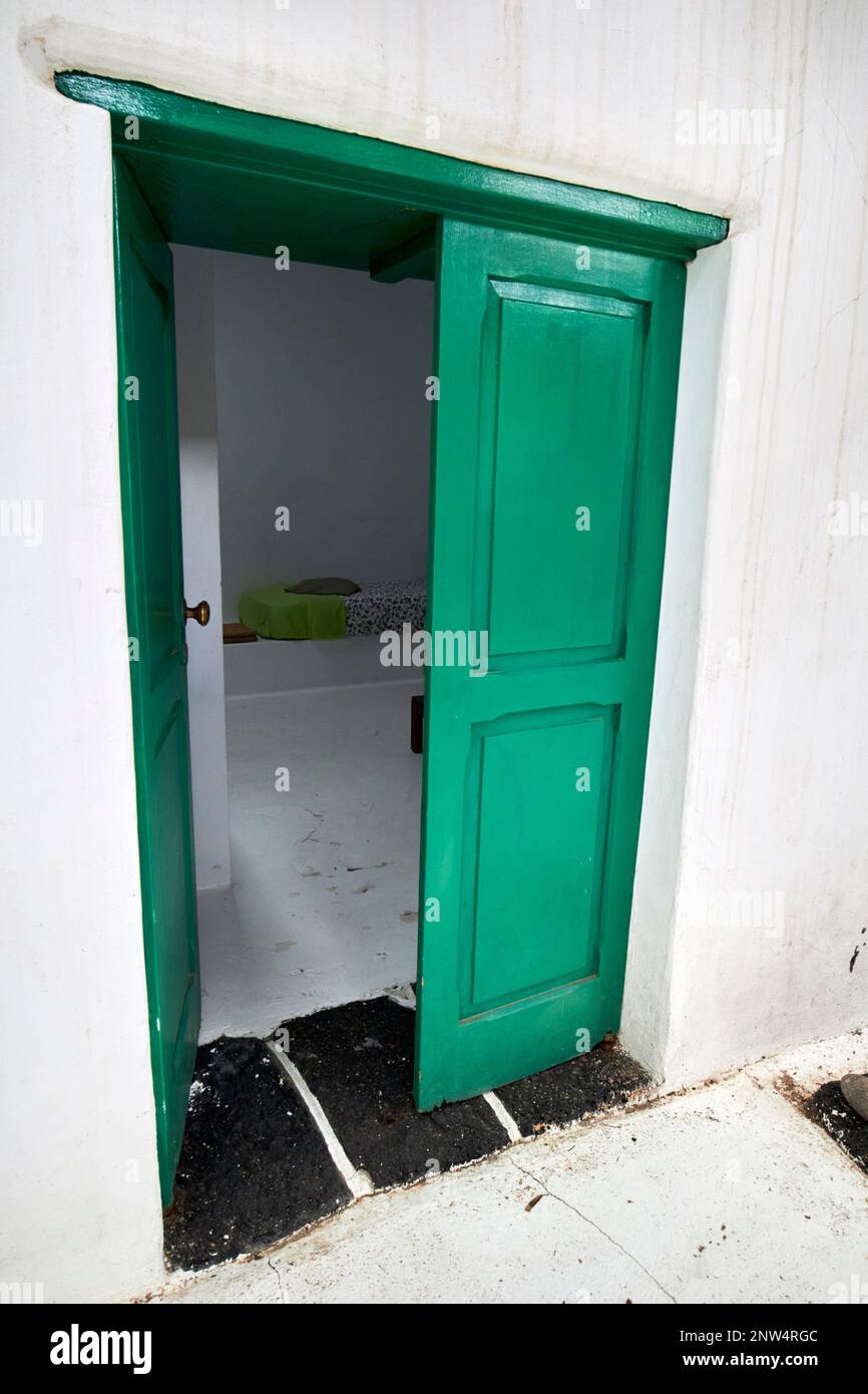 Porta dipinta di verde si apre in camera dal cortile del tradizionale finca casa colonica imbiancata dimora storica a Lanzarote, Isole Canarie, S Foto Stock