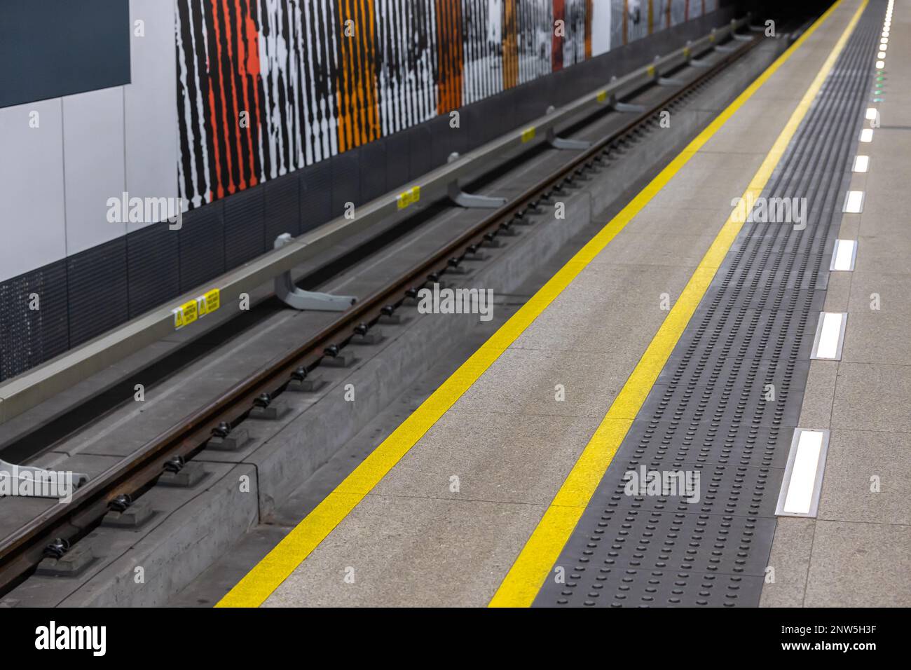 Linee di avvertimento gialle su una piattaforma della metropolitana o della stazione ferroviaria. Sistemi di sicurezza nel traffico pedonale urbano Foto Stock