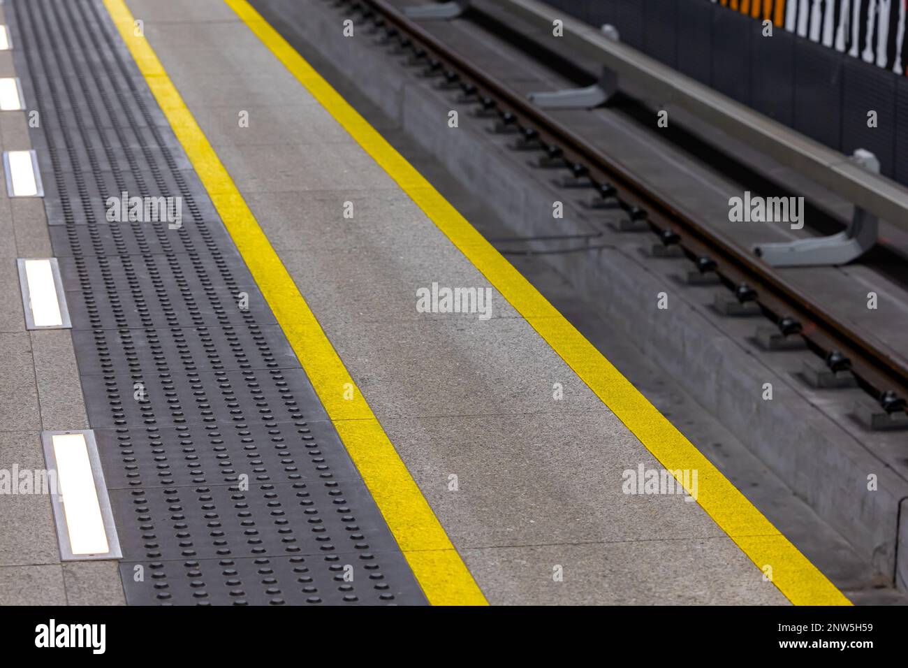 Linee di avvertimento gialle su una piattaforma della metropolitana o della stazione ferroviaria. Sistemi di sicurezza nel traffico pedonale urbano Foto Stock