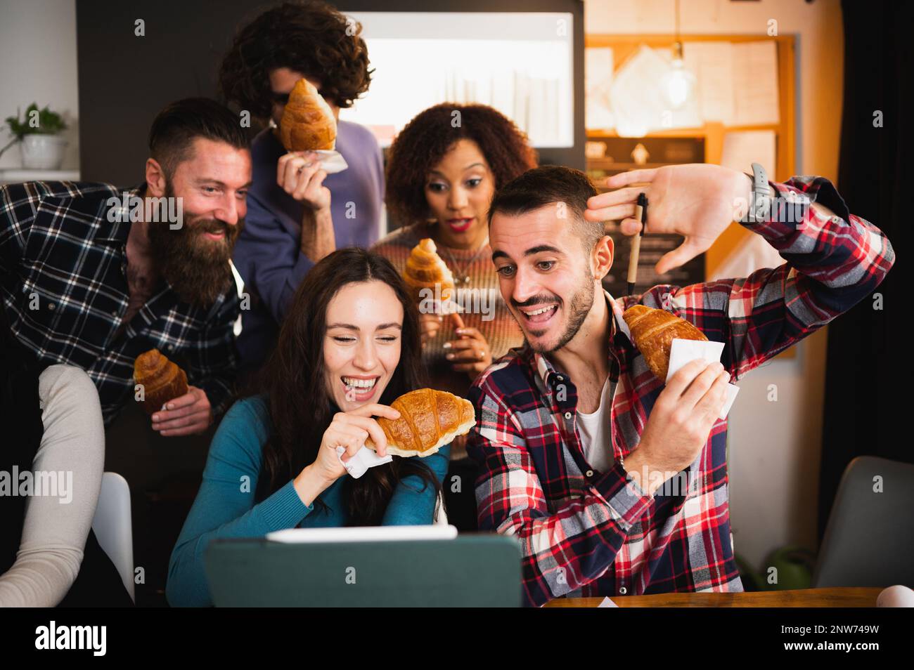 Gruppo di giovani colleghi o studenti che utilizzano il computer portatile e si divertono durante una pausa. Foto Stock