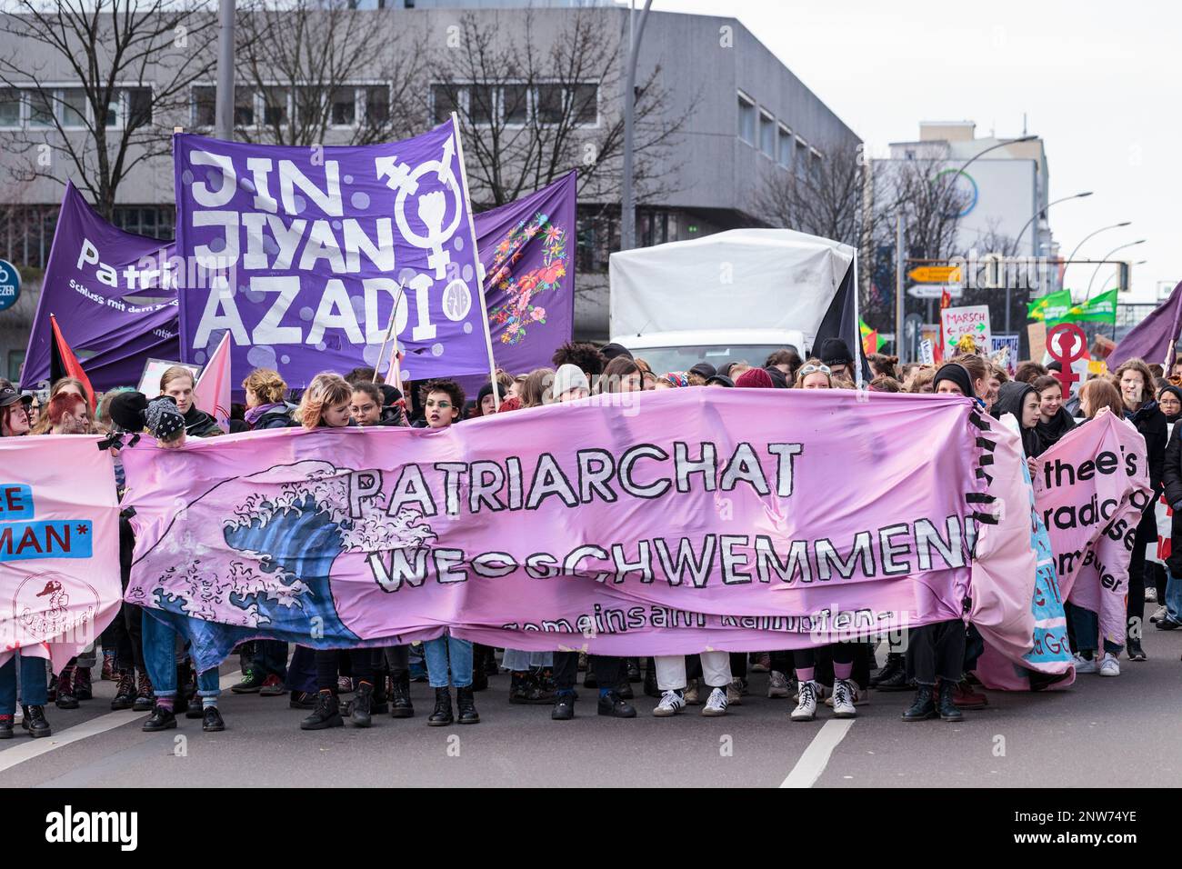 Berlino, Germania 3/8/2020 le donne marciano durante la dimostrazione del giorno dei combattimenti tenendo una grande bandiera di protesta che critica le strutture patriarcali nella società Foto Stock