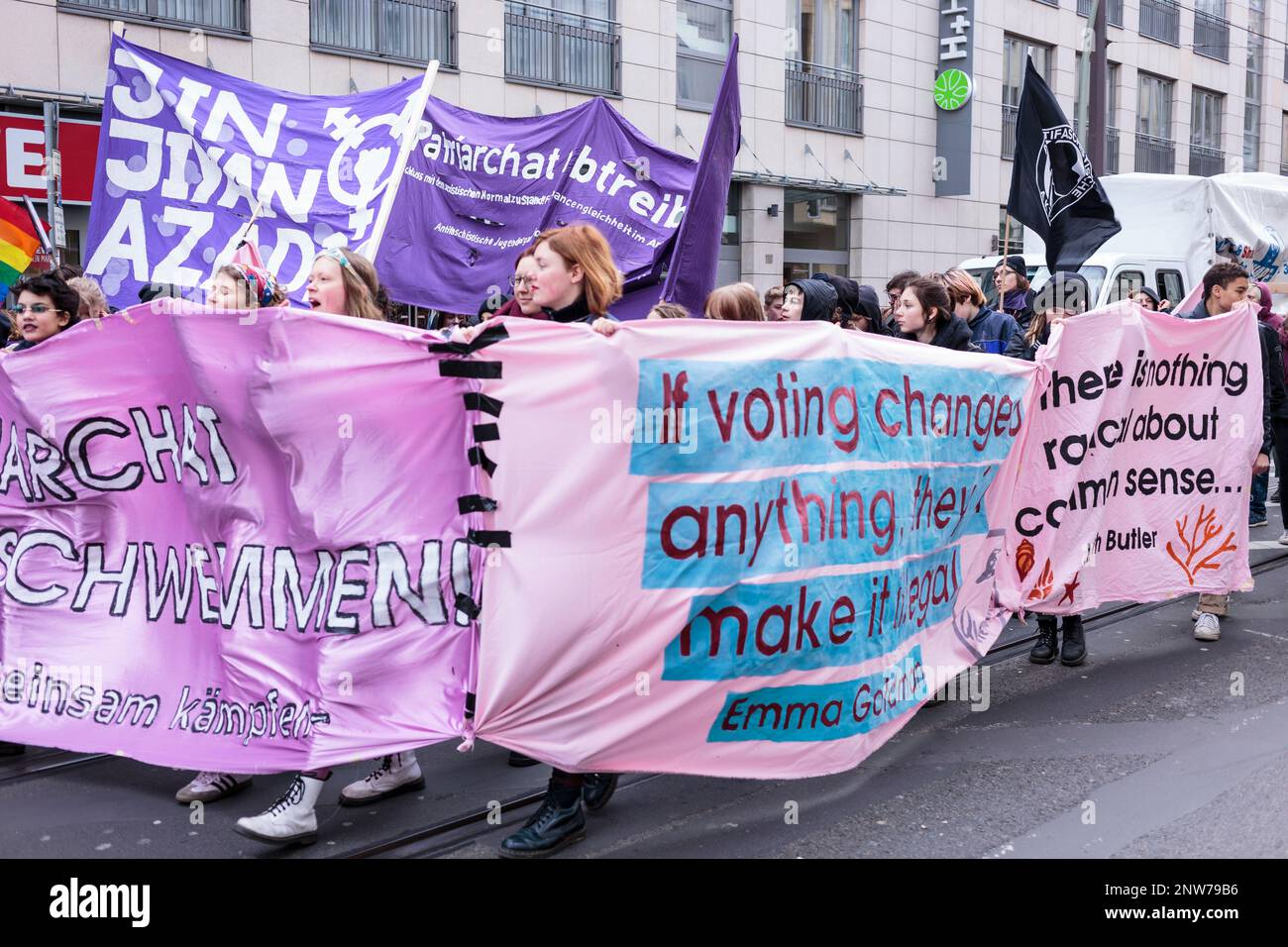 Berlino, Germania 3/8/2020 le donne marciano durante la dimostrazione del giorno dei combattimenti tenendo una grande bandiera di protesta che critica le strutture patriarcali nella società Foto Stock