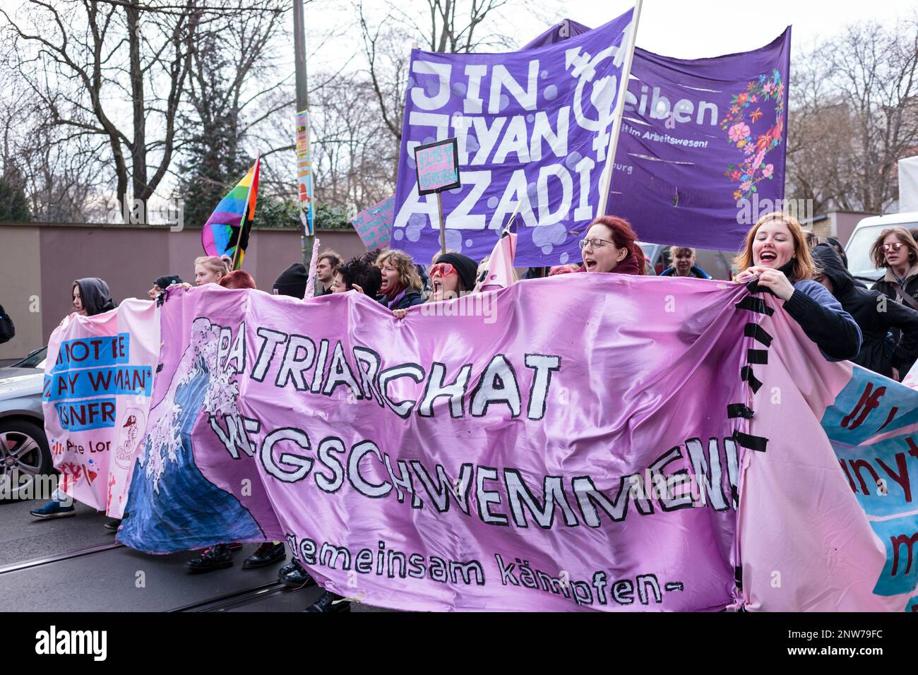 Berlino, Germania 3/8/2020 le donne marciano durante la dimostrazione del giorno dei combattimenti tenendo una grande bandiera di protesta che critica le strutture patriarcali nella società Foto Stock