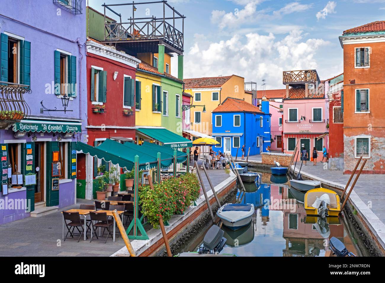 Ristoranti colorati e case dai colori vivaci lungo il canale di Burano, isola nella laguna veneta vicino a Venezia, Veneto, Italia settentrionale Foto Stock