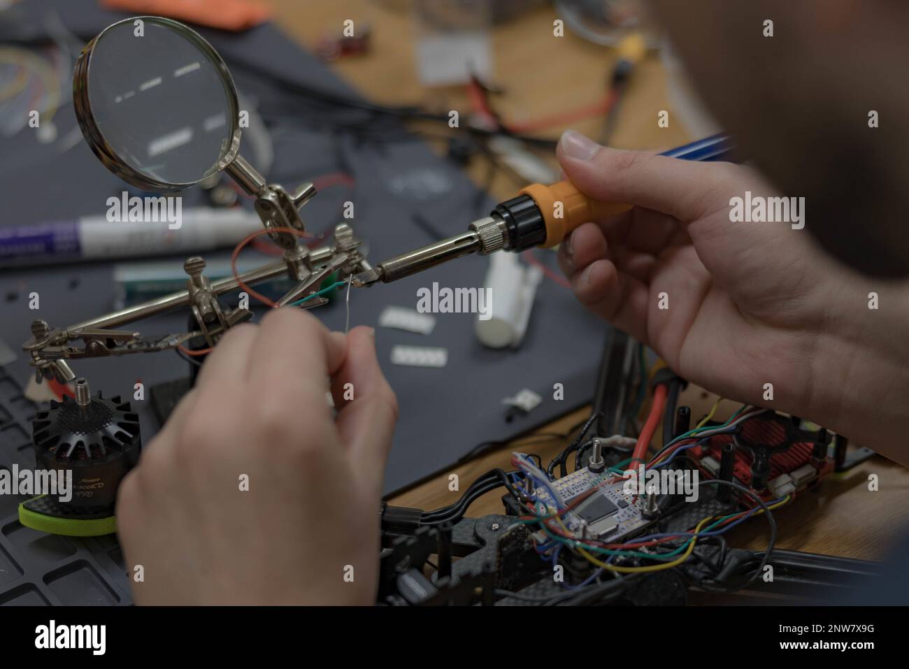Jeremy Brown, un socio di addestramento con il Momentum di costruzione, saldano le attrezzature durante il campo di caricamento di innovazione a Camp Hansen, Okinawa, Giappone, 7 febbraio 2023. I dipendenti di IBC hanno insegnato a Marines competenze quali saldatura, stampa 3D, codifica e programmazione per creare prodotti innovativi per il corpo marino e testare le capacità di pensiero critico di Marines. Foto Stock