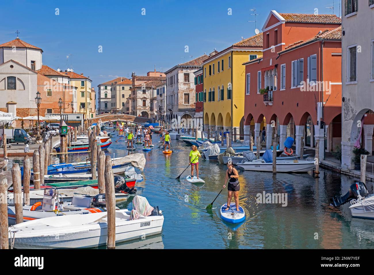 I turisti che si trovano sul canale Vena a Chioggia, piccola isola all'ingresso sud della laguna veneta vicino a Venezia, Veneto, Italia settentrionale Foto Stock