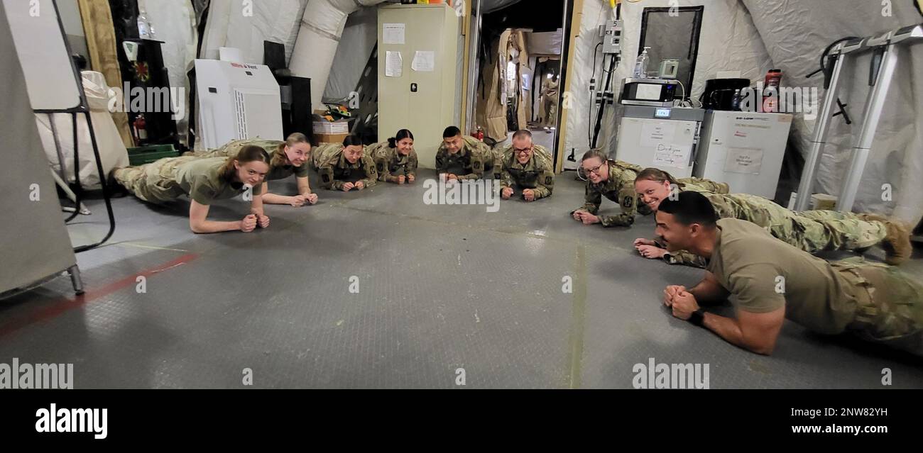 Joint Task Force Med 374 soldati prendere una breve pausa dal lavoro al ruolo III Hospital Center per ottenere in qualche tempo in tavola in preparazione per l'ACFT. Foto Stock