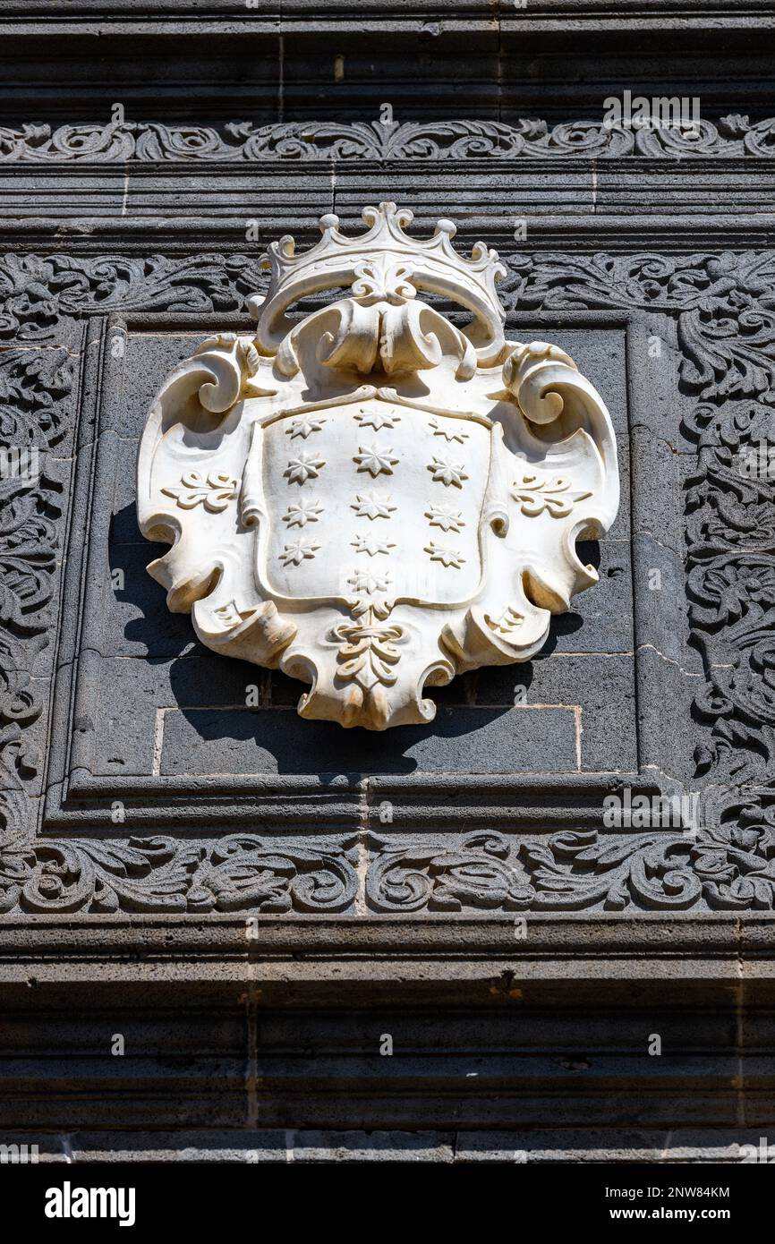 Lo stemma di Salazar in marmo bianco di Carrara contrasta nettamente con la facciata ornata in pietra blu scuro del Palazzo Salazar a la Laguna, Tenerife Foto Stock