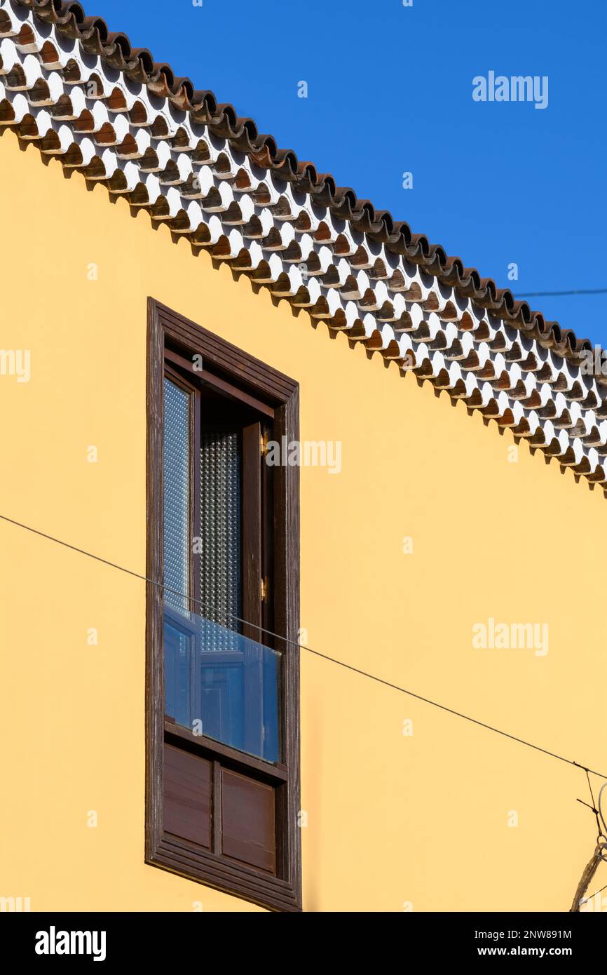 Intricate file di Génoise lavato in bianco contrastano con una parete in stucco giallo brillante su un edificio a San Cristobal de la Laguna a Tenerife Foto Stock