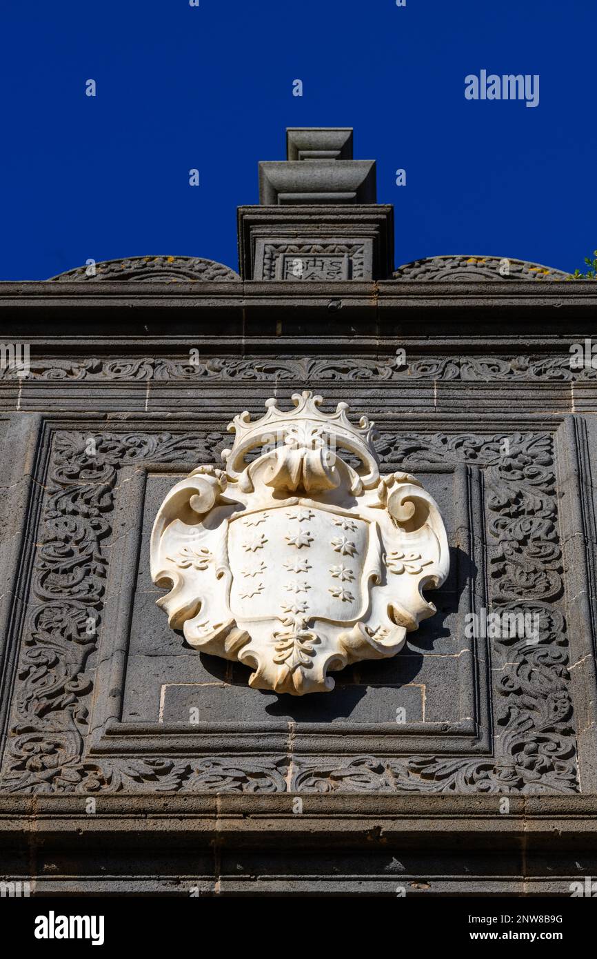 Lo stemma di Salazar in marmo bianco di Carrara contrasta nettamente con la facciata ornata in pietra blu scuro del Palazzo Salazar a la Laguna, Tenerife Foto Stock