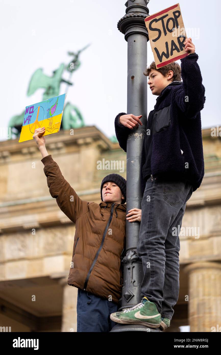 Berlino, Germania 2/27/2022 giovani manifestanti sono appesi ad un palo in un demo anti-guerra contro l'invasione dell'Ucraina da parte della Russia vicino alla porta di Brandeburgo Foto Stock