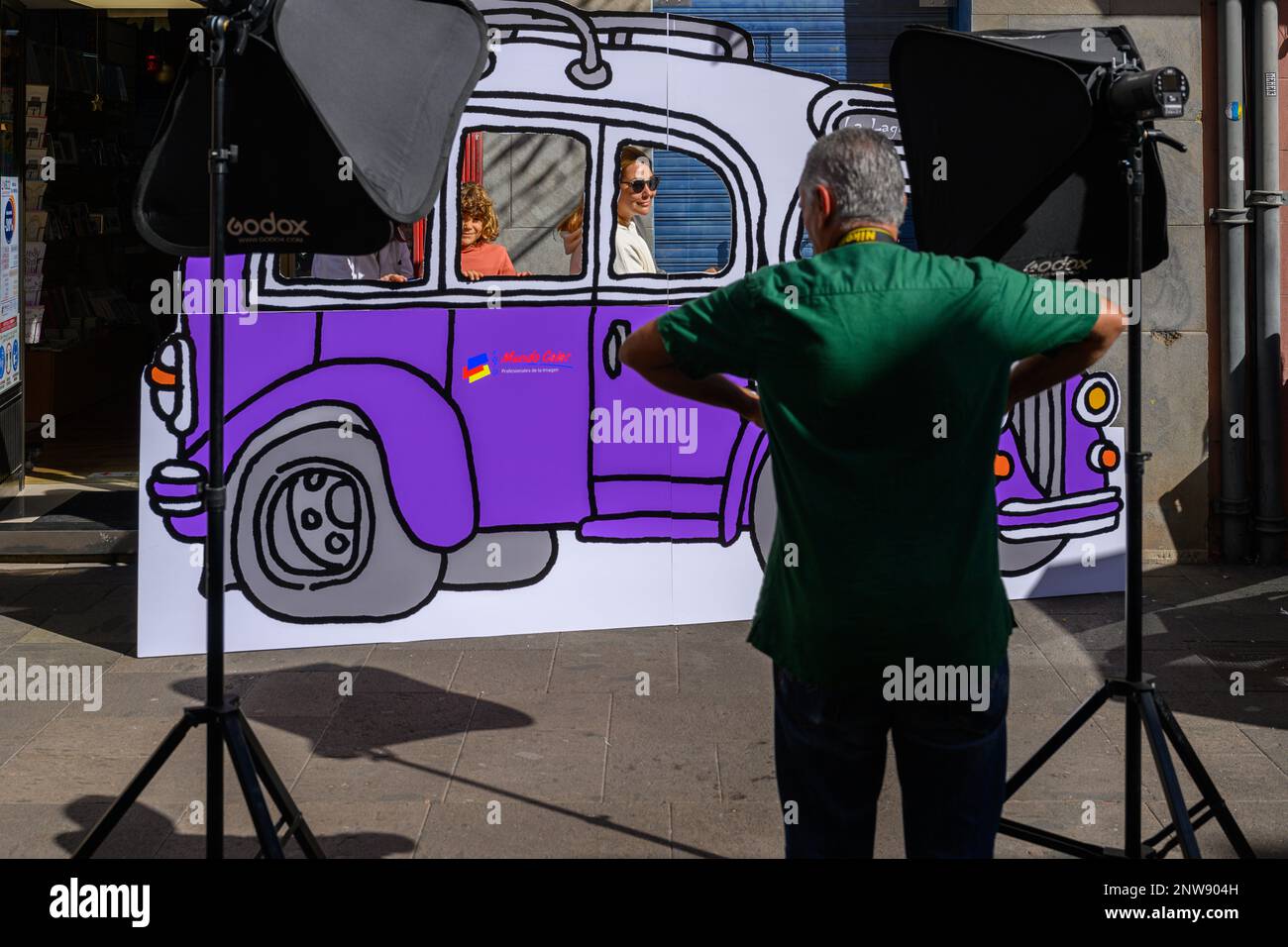 Un fotografo organizza i clienti su un autobus cartoni animati foto Mundo Color come parte del festival la Noche en Blanco a San Cristobal de la Laguna, Tenerife. Foto Stock