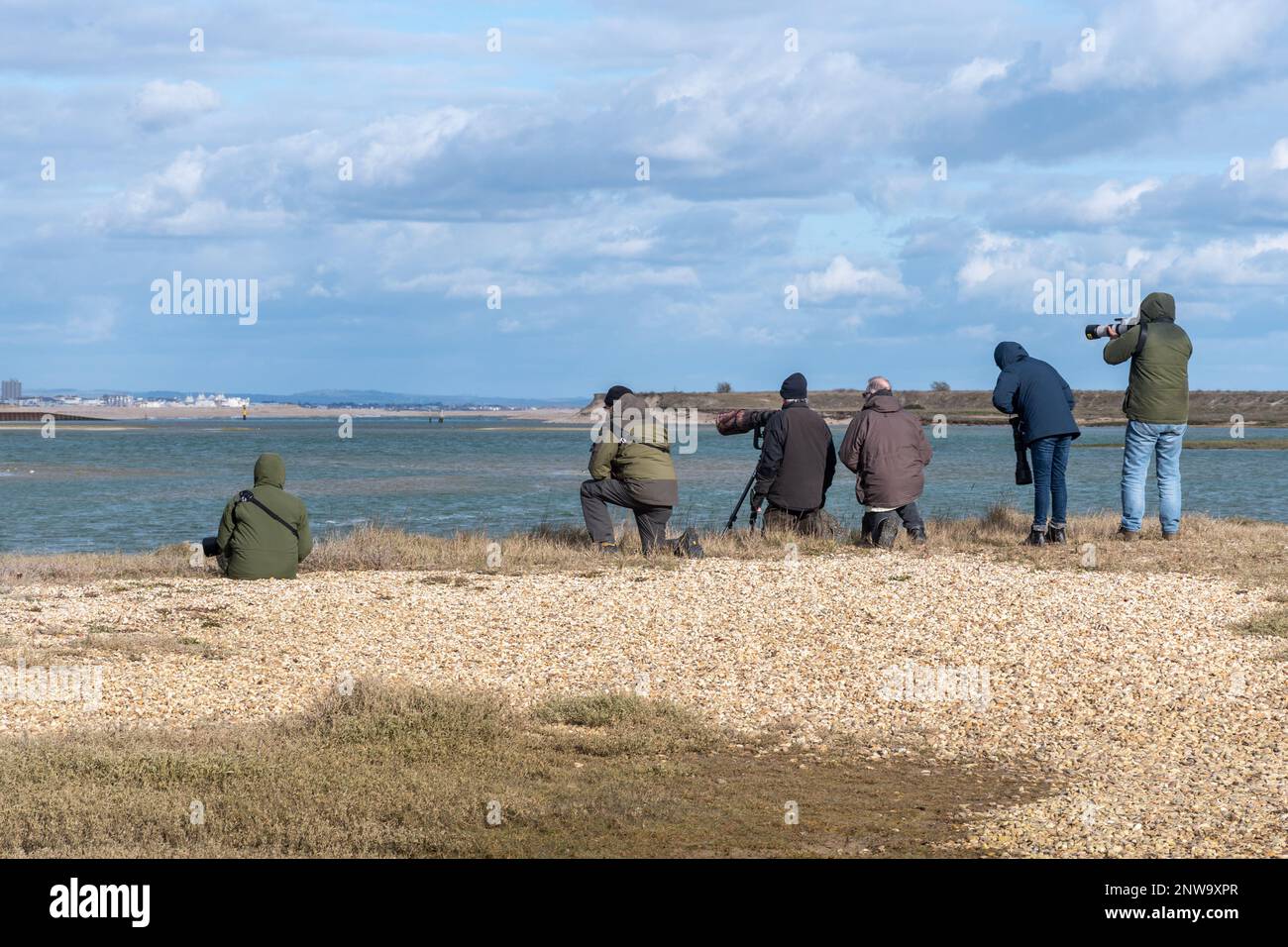 Birdwatchers e fotografi di fauna selvatica che utilizzano fotocamere con teleobiettivi lunghi presso la RSPB Pagham Harbour Nature Reserve, West Sussex, Inghilterra, Regno Unito Foto Stock