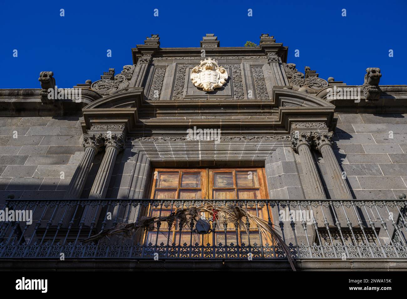 Lo stemma di Salazar in marmo bianco di Carrara contrasta nettamente con la facciata ornata in pietra blu scuro del Palazzo Salazar a la Laguna, Tenerife Foto Stock