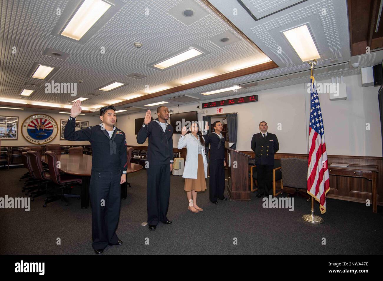I marinai e i familiari con sede a Sasebo si impegnano a dare il giuramento di naturalizzazione di Allegiance agli Stati Uniti d'America durante una cerimonia di naturalizzazione al Comandante, Fleet Activities Sasebo 22 febbraio 2023. STATI UNITI Citizenship and Immigration Services and Region Legal Service Office Western Pacific ha collaborato per condurre la cerimonia di naturalizzazione al CFAS consentendo ai marinai di diventare cittadini degli Stati Uniti. Foto Stock
