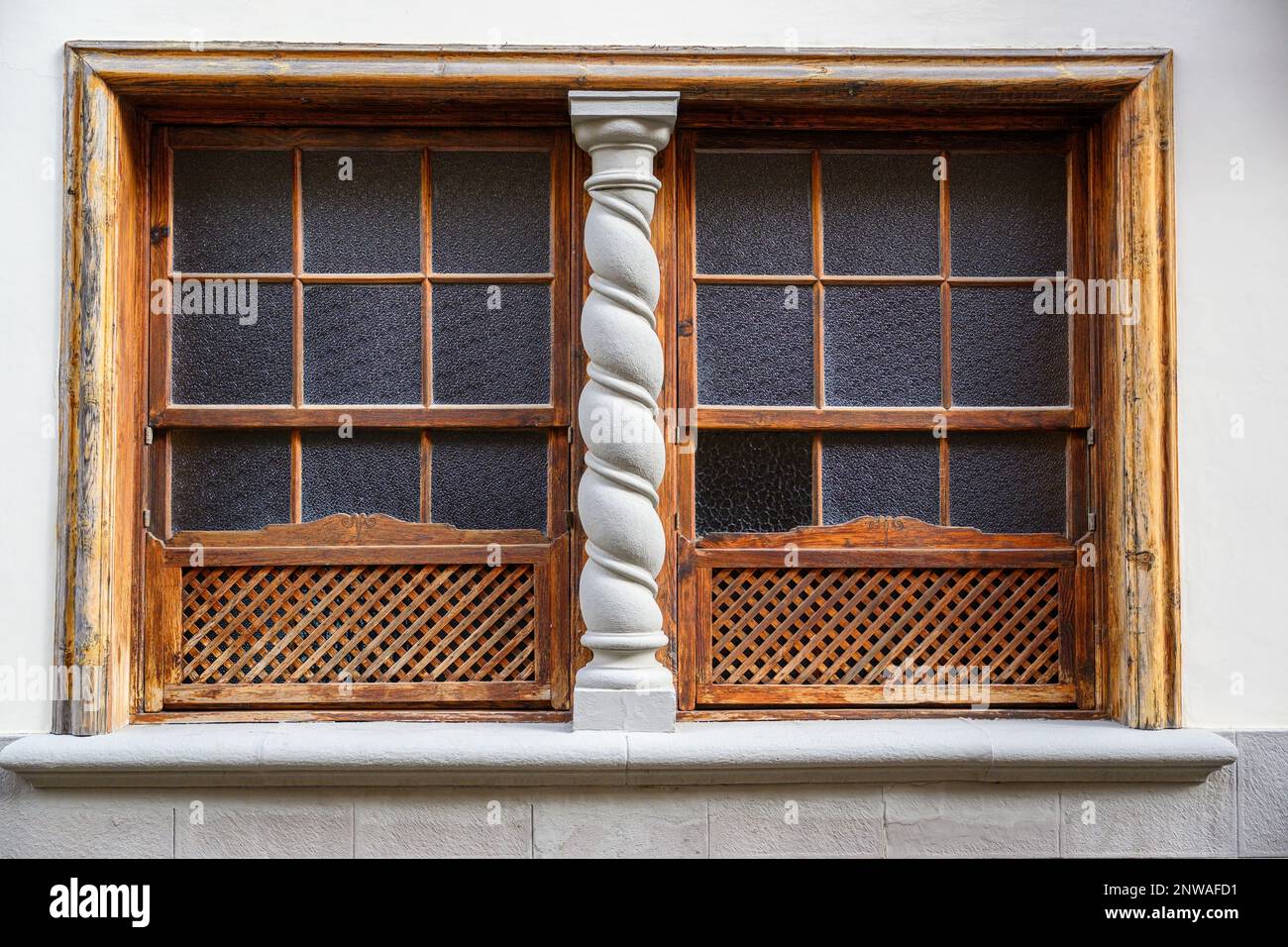 Un'elegante colonna a spirale biseca le tradizionali finestre in legno delle Canarie in un edificio a la Laguna, Tenerife Foto Stock