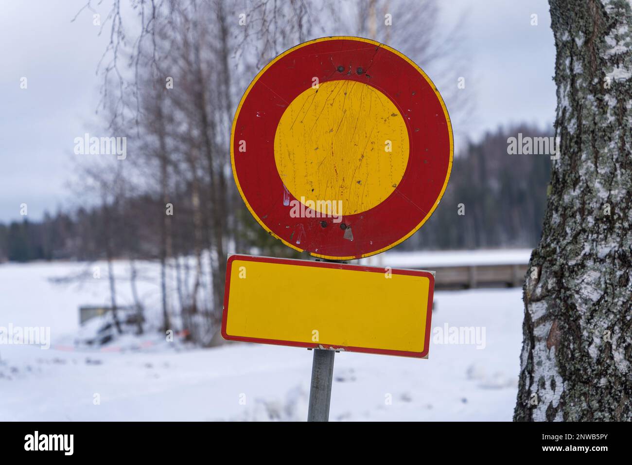 Logoro cartello stradale finlandese vietato all'ingresso in inverno con sotto il cartello giallo vuoto. Cerchio rosso intorno al centro giallo Foto Stock
